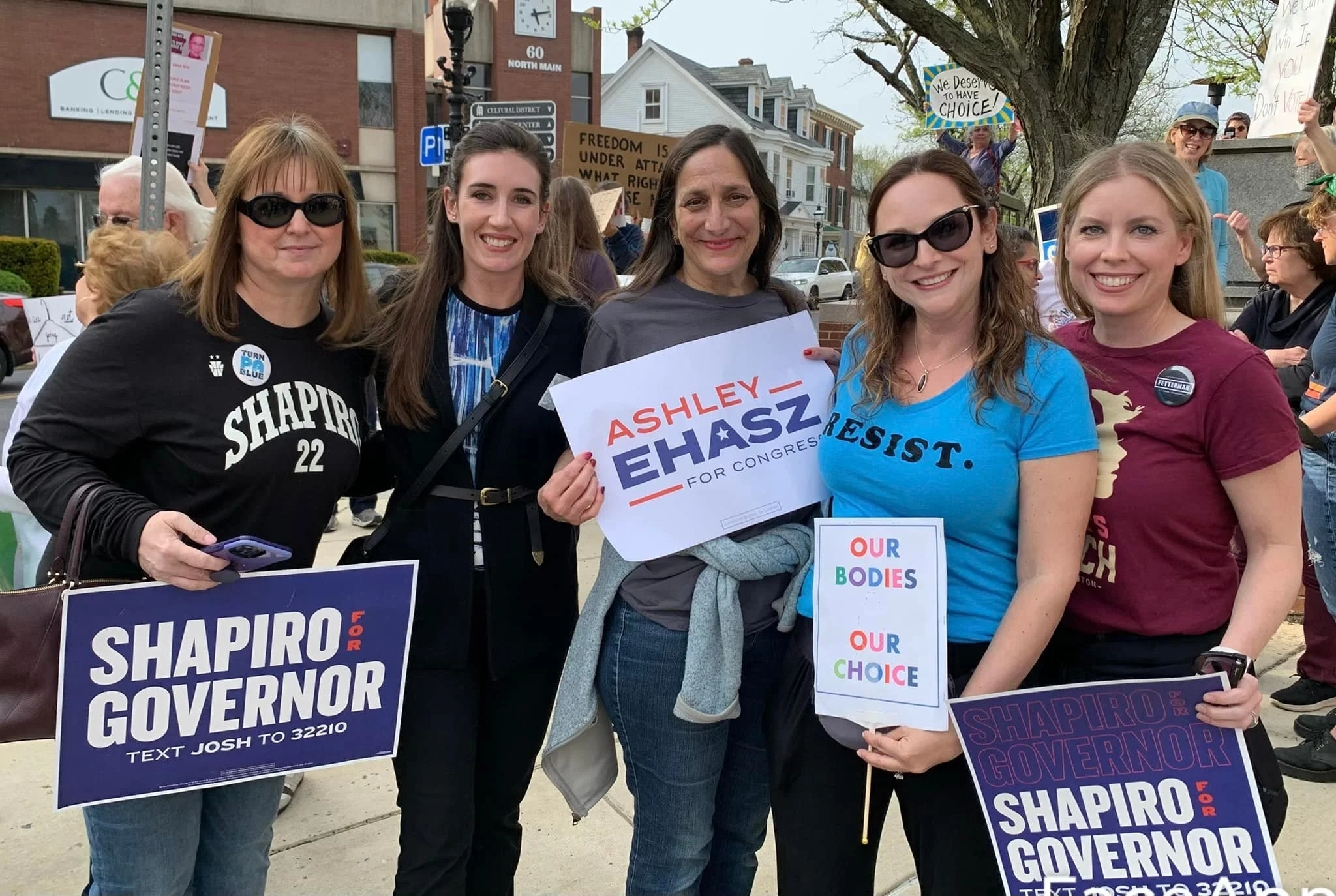 Ashley in a group of attendees to an event with Governor Shapiro and Ashley Ehasz signs
