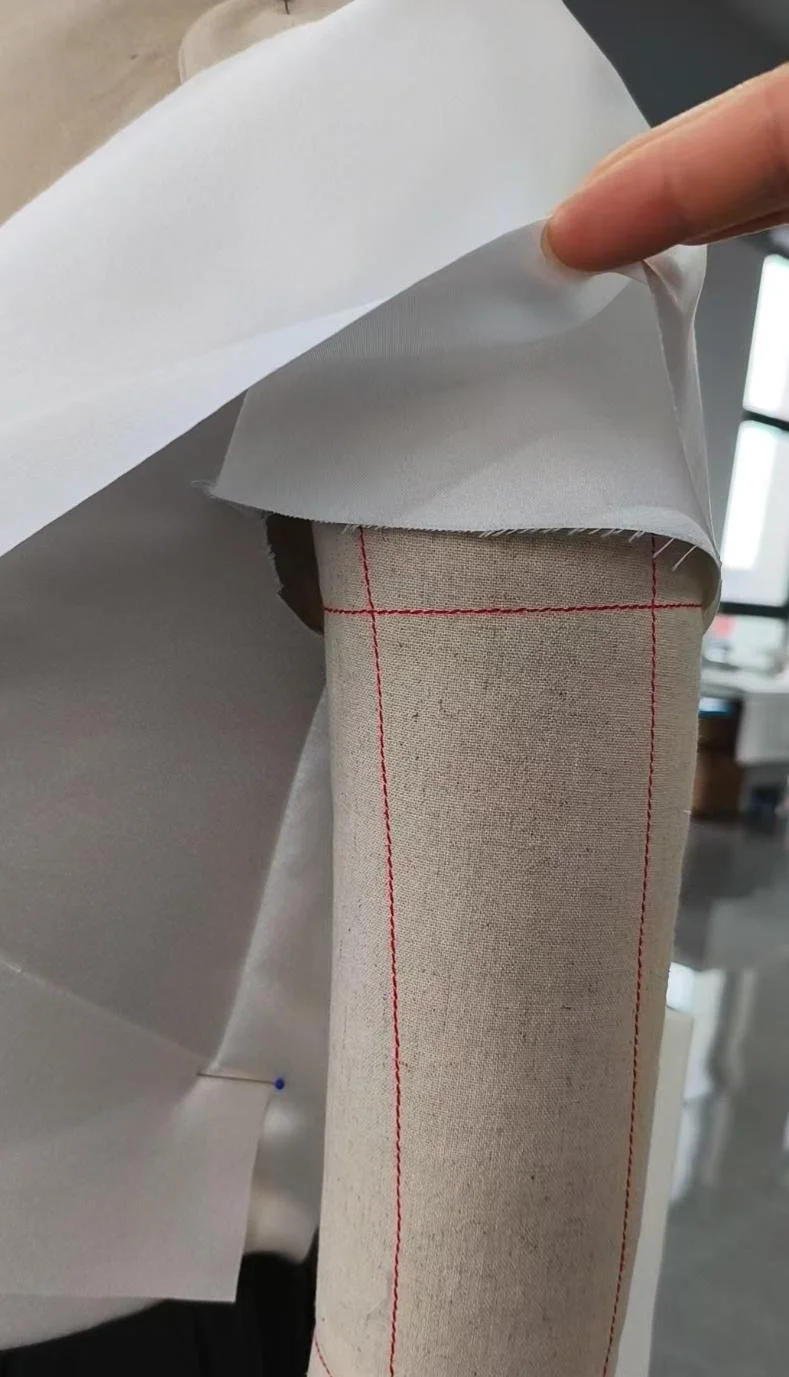 Persona colocando papel decorativo sobre un tubo de cartón.