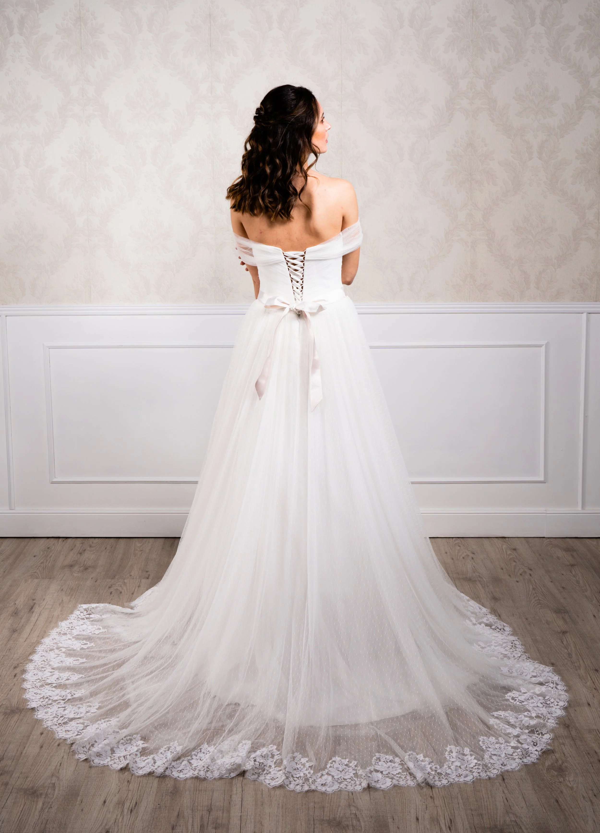 Vestido de corte en A elaborado con tul plumeti en la falda y tul suave en el cuerpo, acompañado de puntilla de encaje en el bajo y tirantes fantasia.