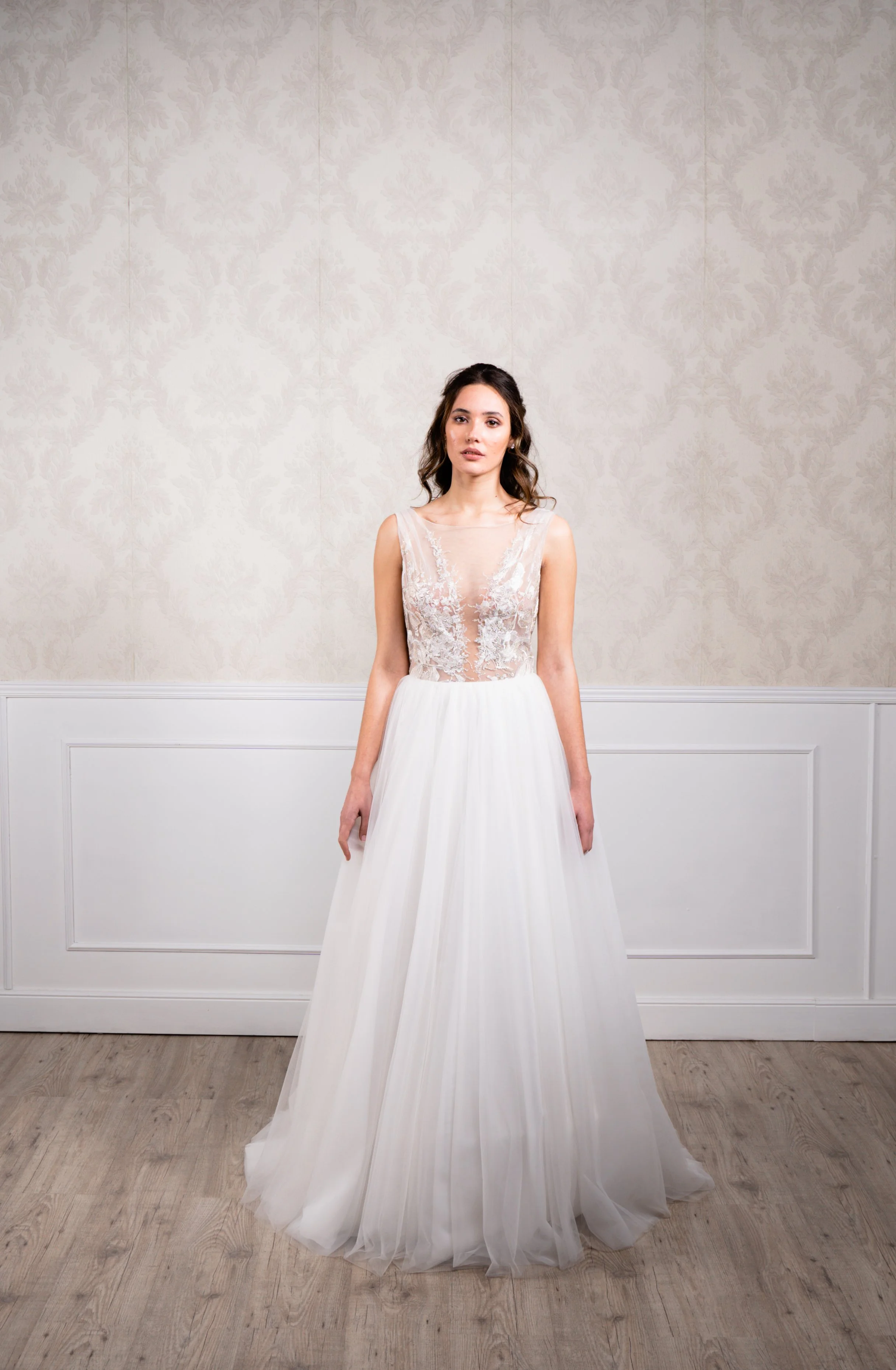 Vestido en silueta A elaborado en tul suave , tul bordado en hilo plata y escote plisado en espalda.