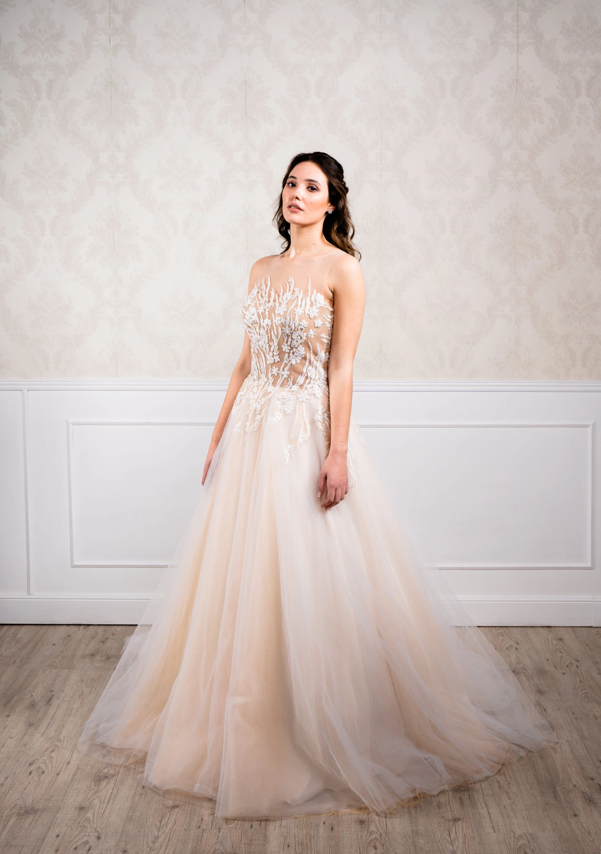 Vestido de corte en A elaborado con distintos tonos de tul blanco y toffe, cuerpo efecto piel de encaje de algodón blanco con pedrería blanca.