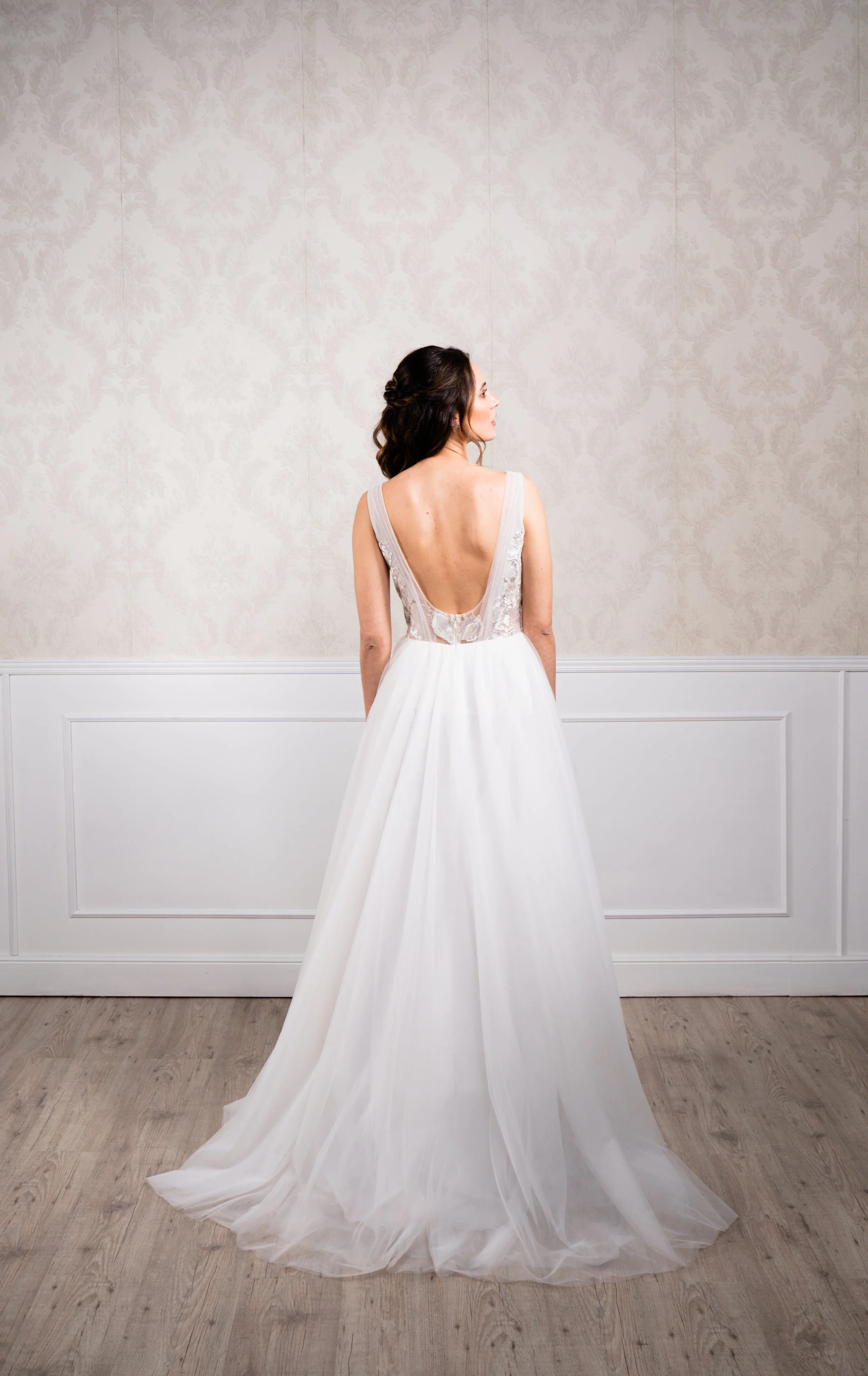 Vestido en silueta A elaborado en tul suave , tul bordado en hilo plata y escote plisado en espalda.