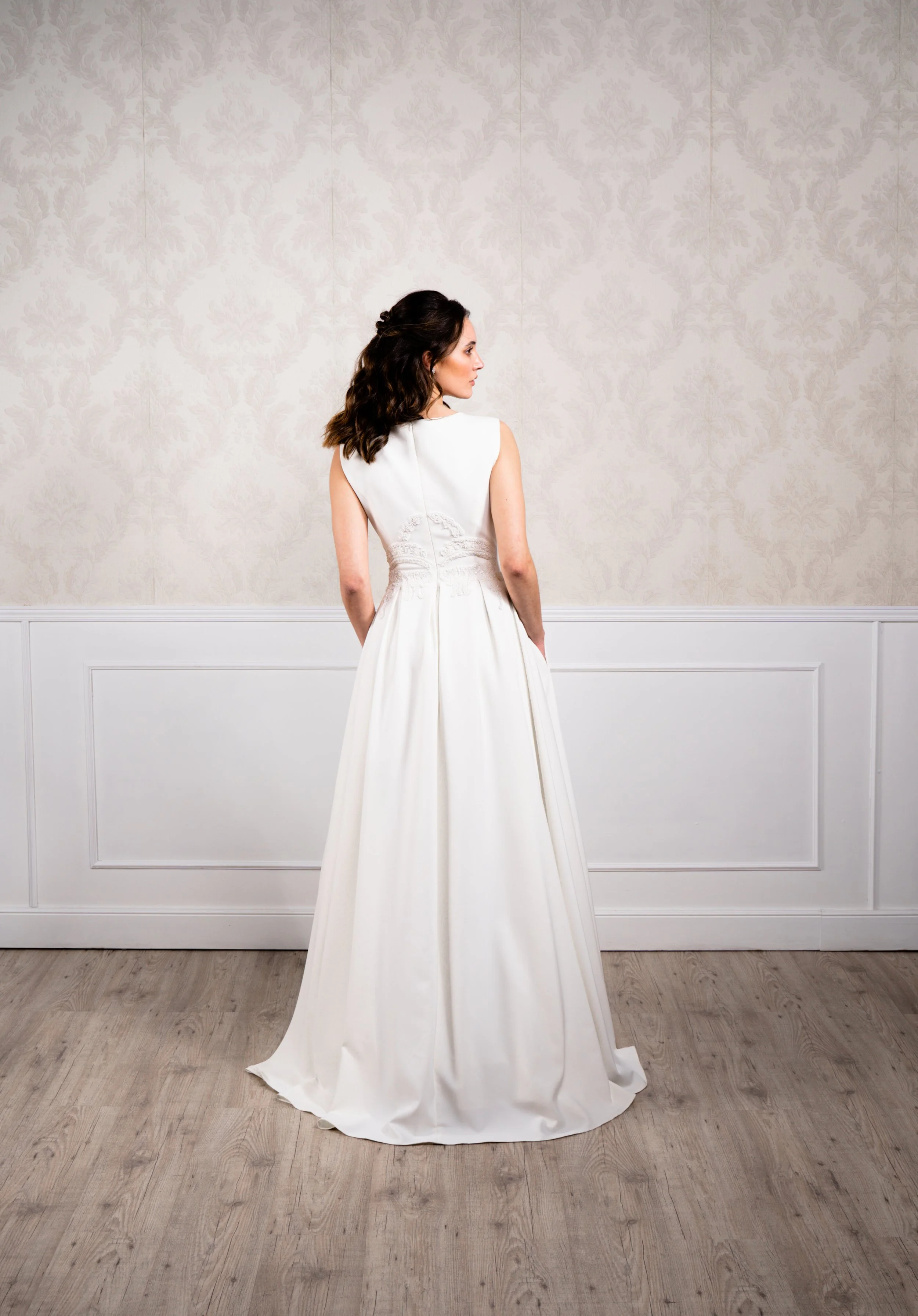 Vestido de corte en A elaborado con tejido de punto elástico, dándole una caída sutil y suave, acompañado de pedrería blanca en el cuerpo y manga a la sisa.