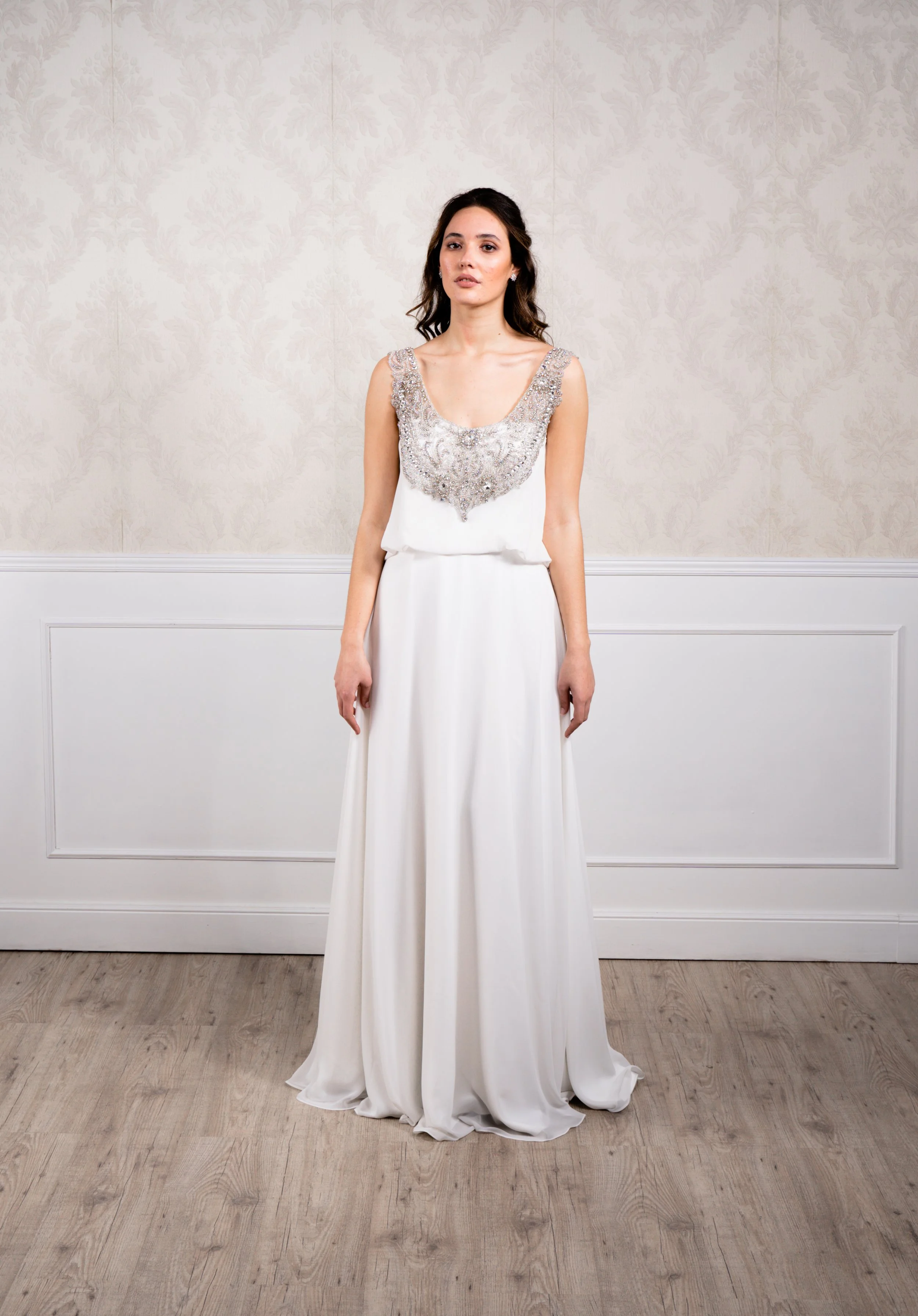 Vestido en silueta A elaborado en chiflón y gasa con corte inspiración griego, detalles de cristal envejecido en escote y espalda.