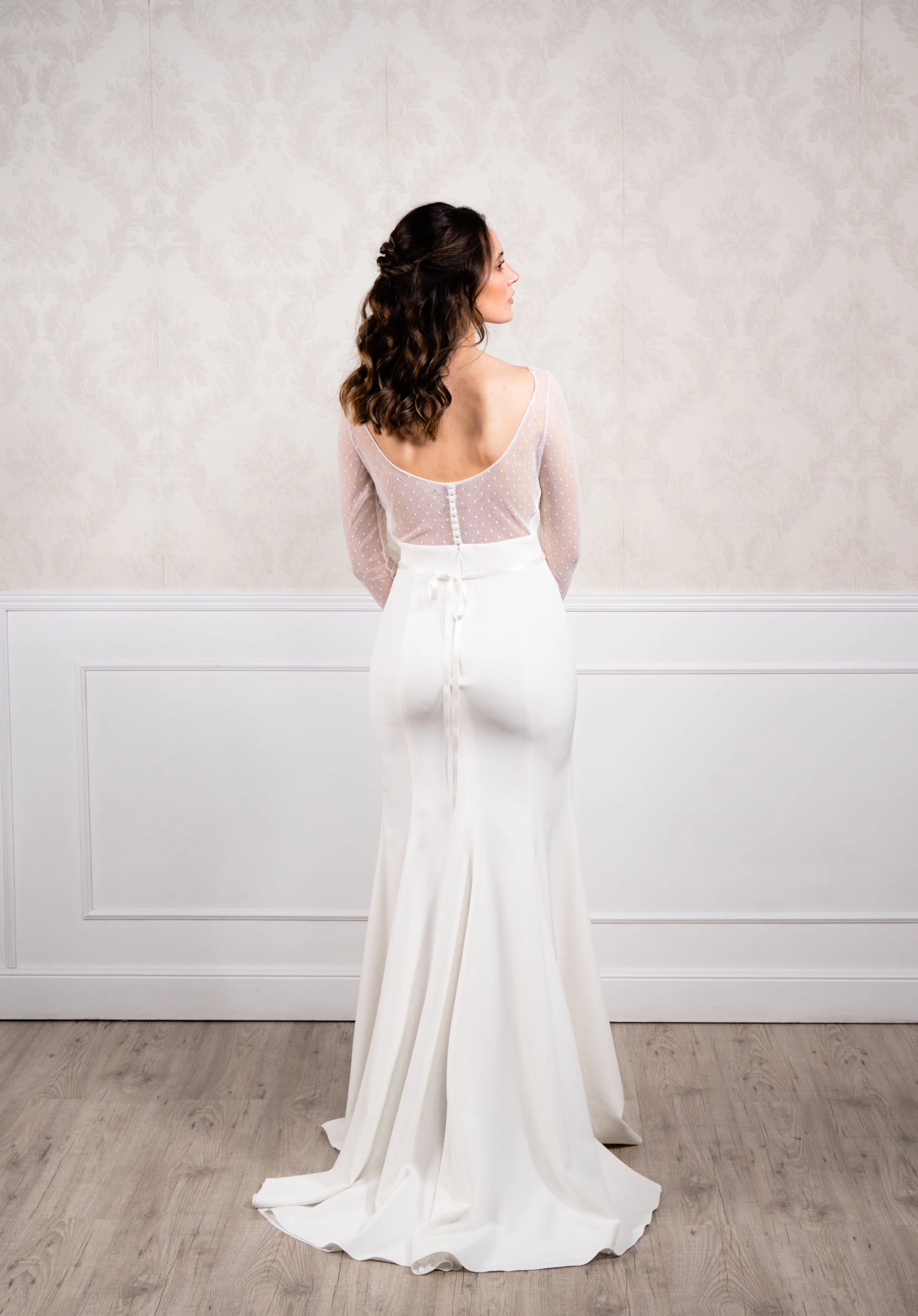 Vestido de corte recto elaborado en punto elástico con mangas en tul plumeti, escote en espalda y apertura delantera.