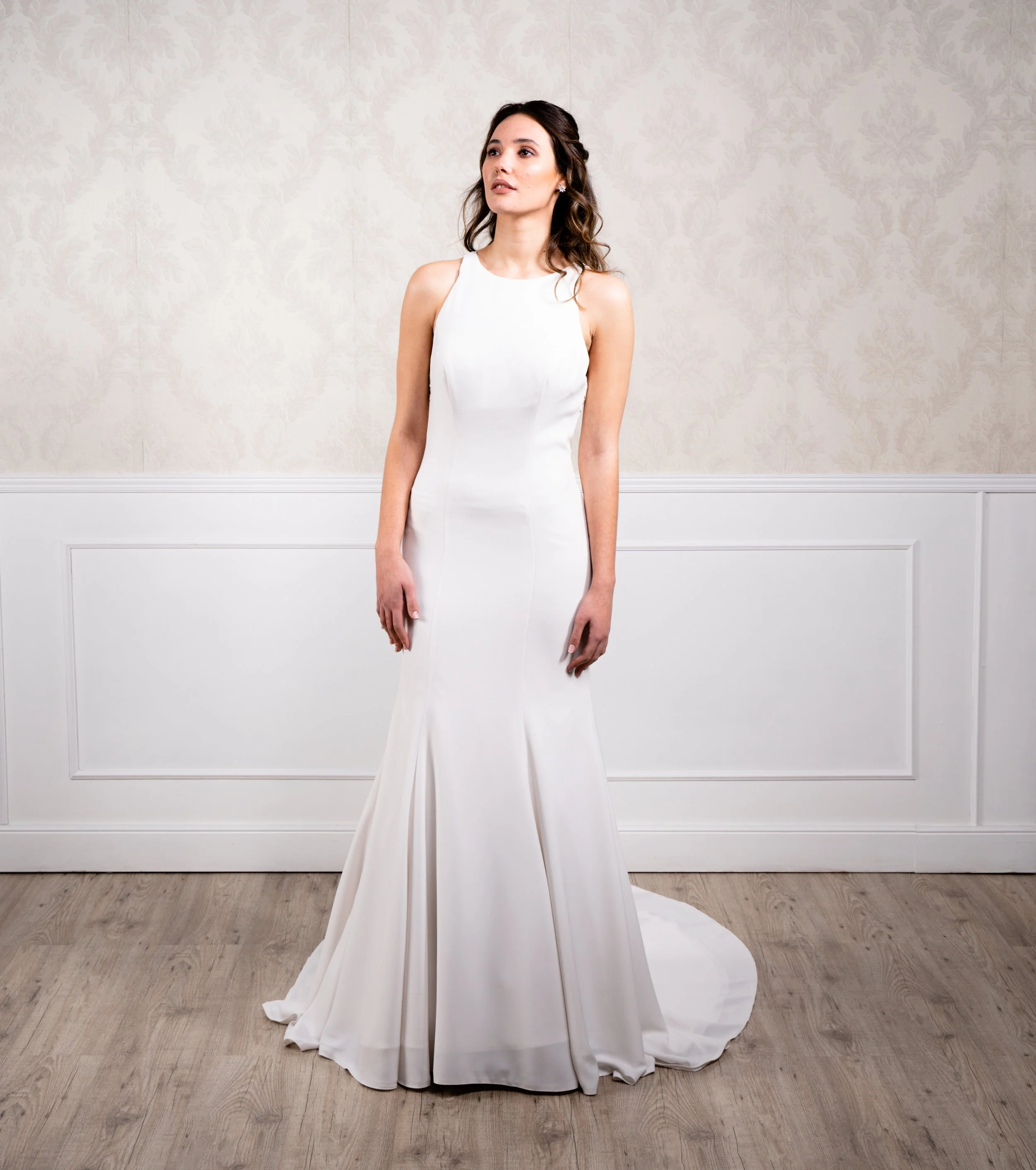 Vestido de corte sirena elaborador en crep suave y espalda bordada con encaje de algodón natural, escote halter y botonadura decorativa hasta la cola.