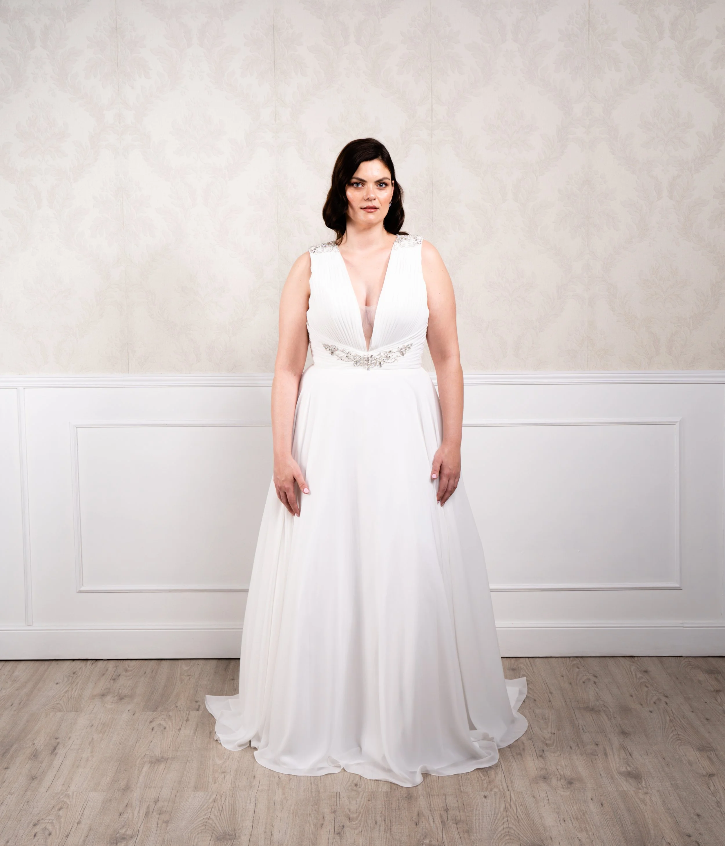 Vestido en forma de A, escote pronunciado y espalda abierta, elaborado con gasa y pedrería en escote y tirante.