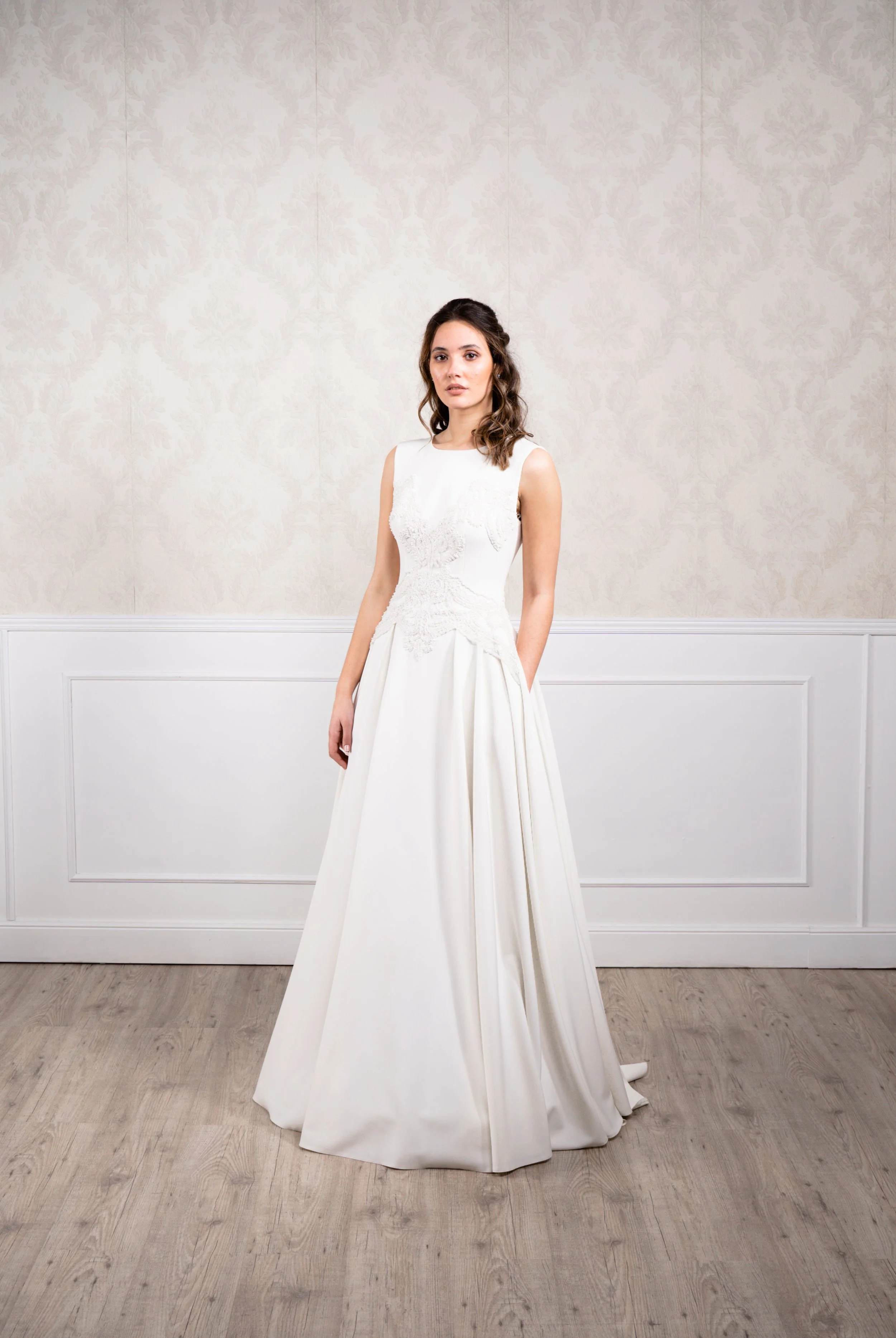 Vestido de corte en A elaborado con tejido de punto elástico, dándole una caída sutil y suave, acompañado de pedrería blanca en el cuerpo y manga a la sisa.