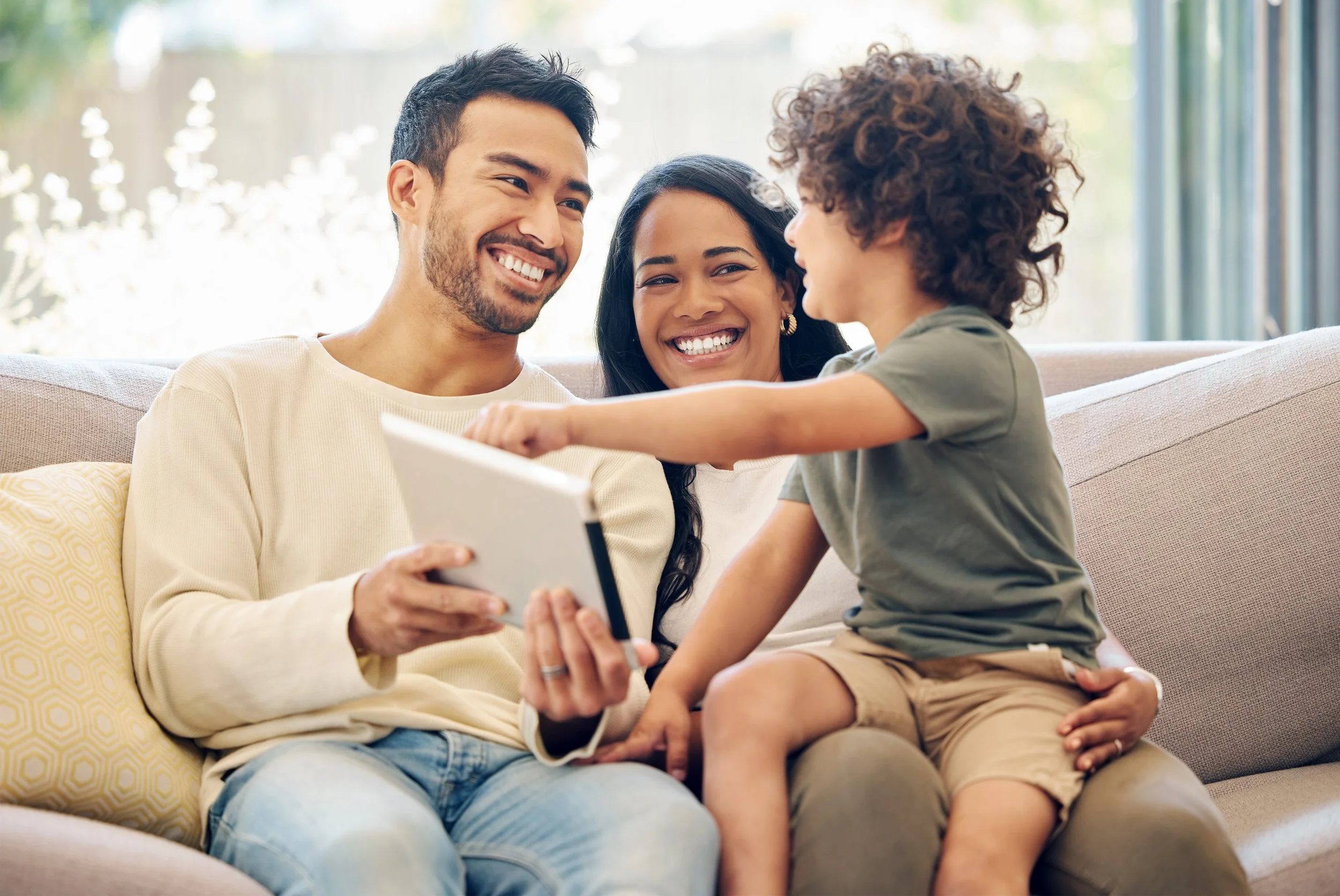 Two foster parents share a laugh with a child.