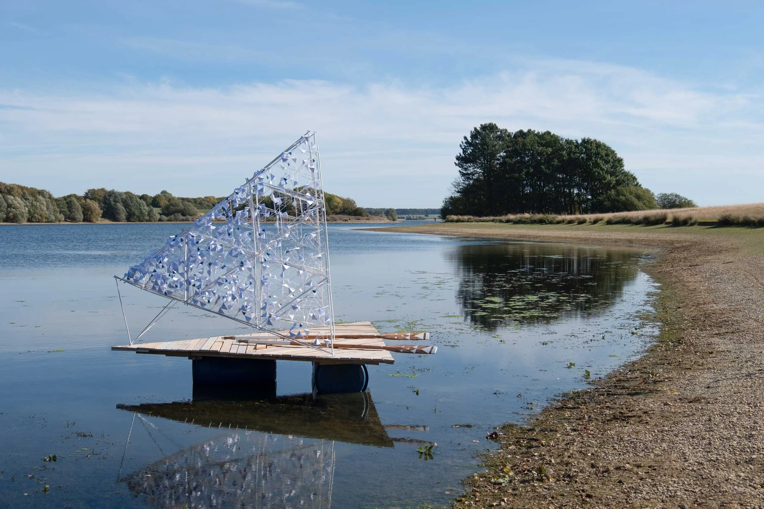 Timber raft and paper canopy by the shore