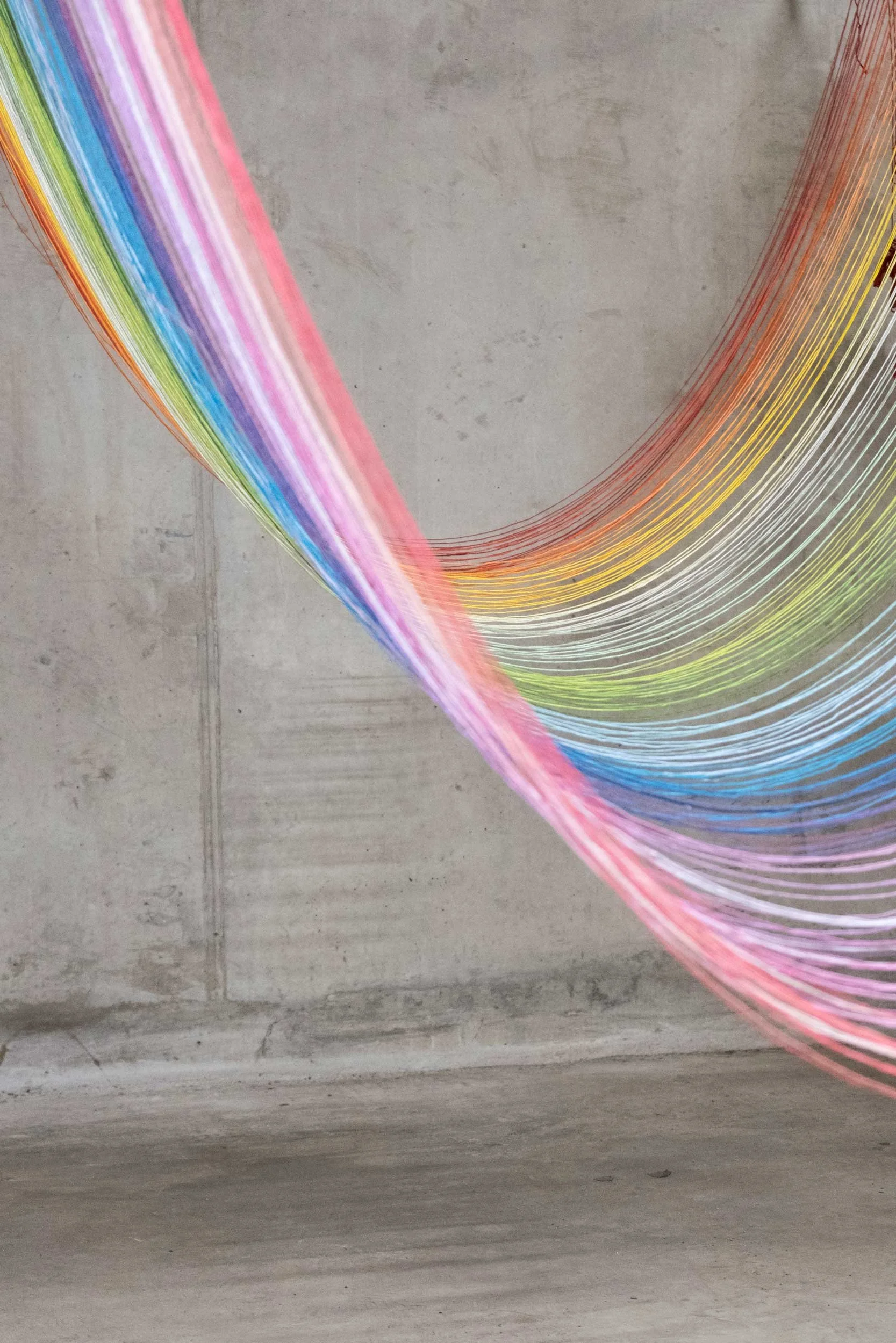 Rainbow thread colours against grey background