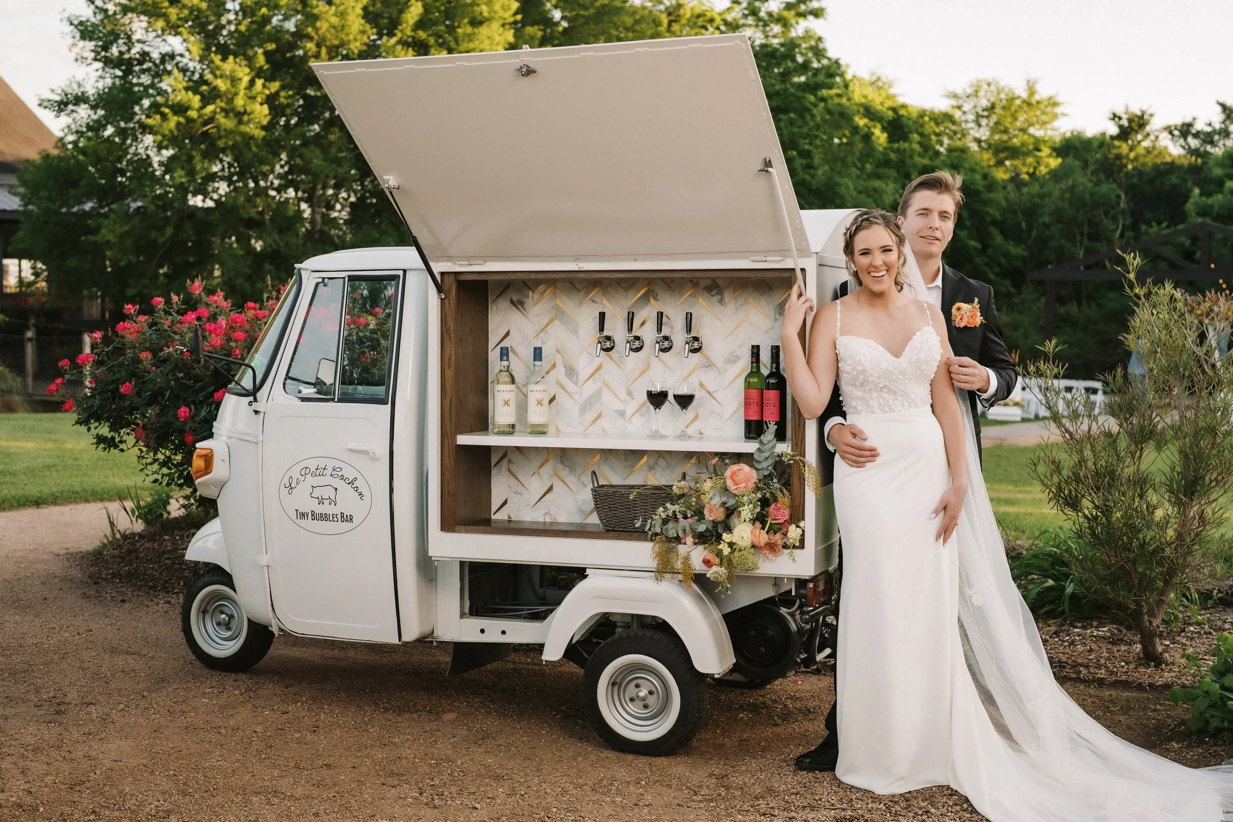 tiny bubbles bar lid open with bride and groom beside.jpg