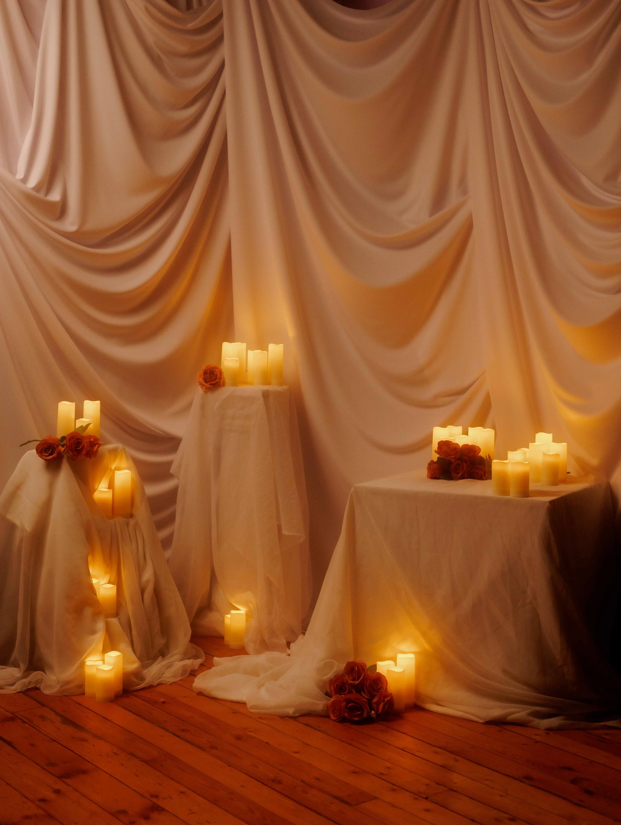A soft, romantic photography set featuring flowing draped fabric and warm candlelight at Studio Ethereal in Hamilton, Ontario.