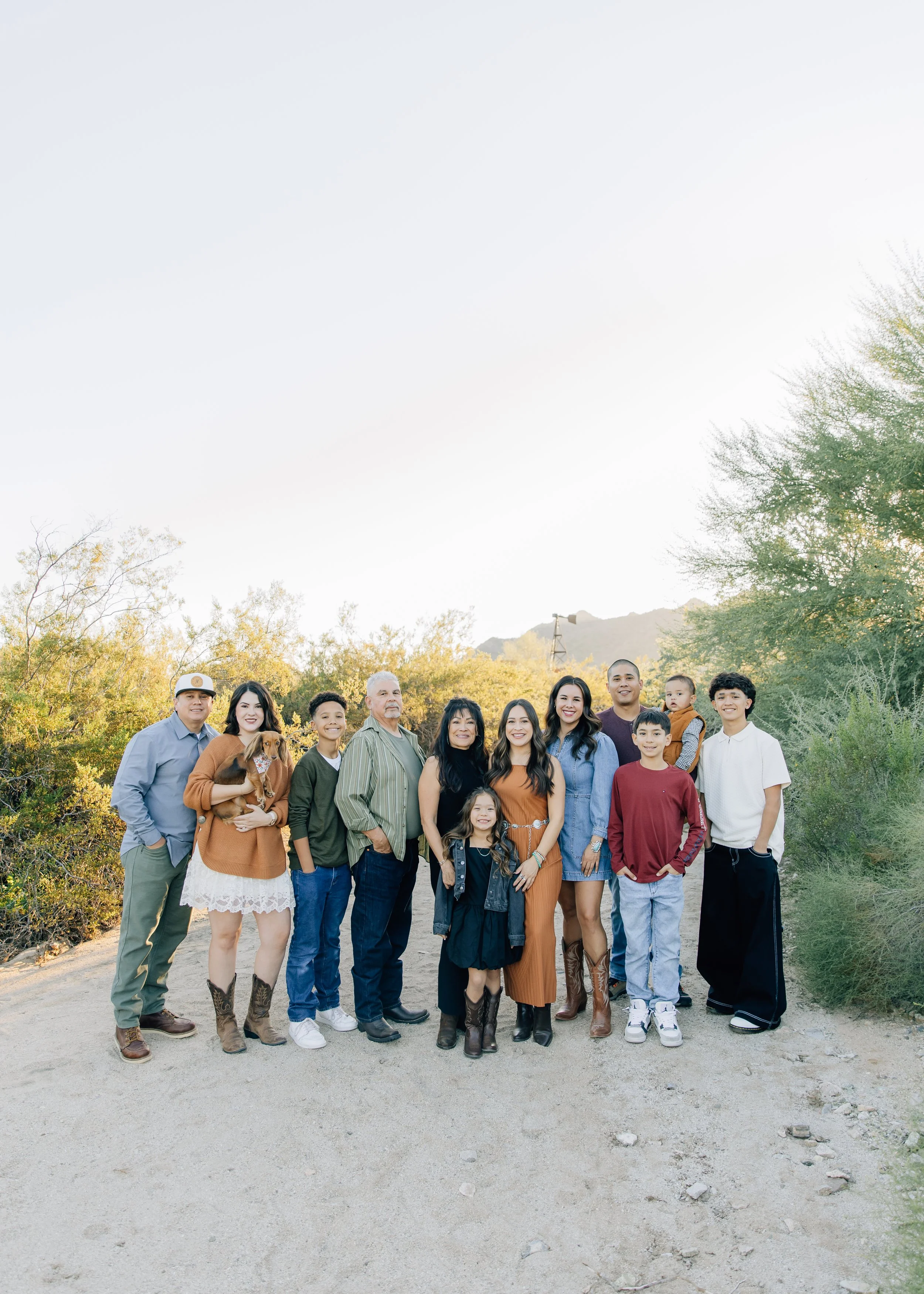 Family photo outdoors with desert plants in the background, sunlight, and desert landscape.