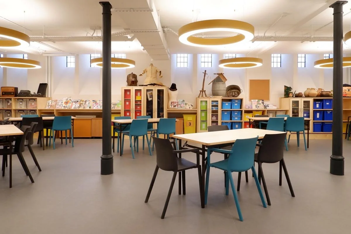 Colourful chairs, tables and bookshelves in an open plan space