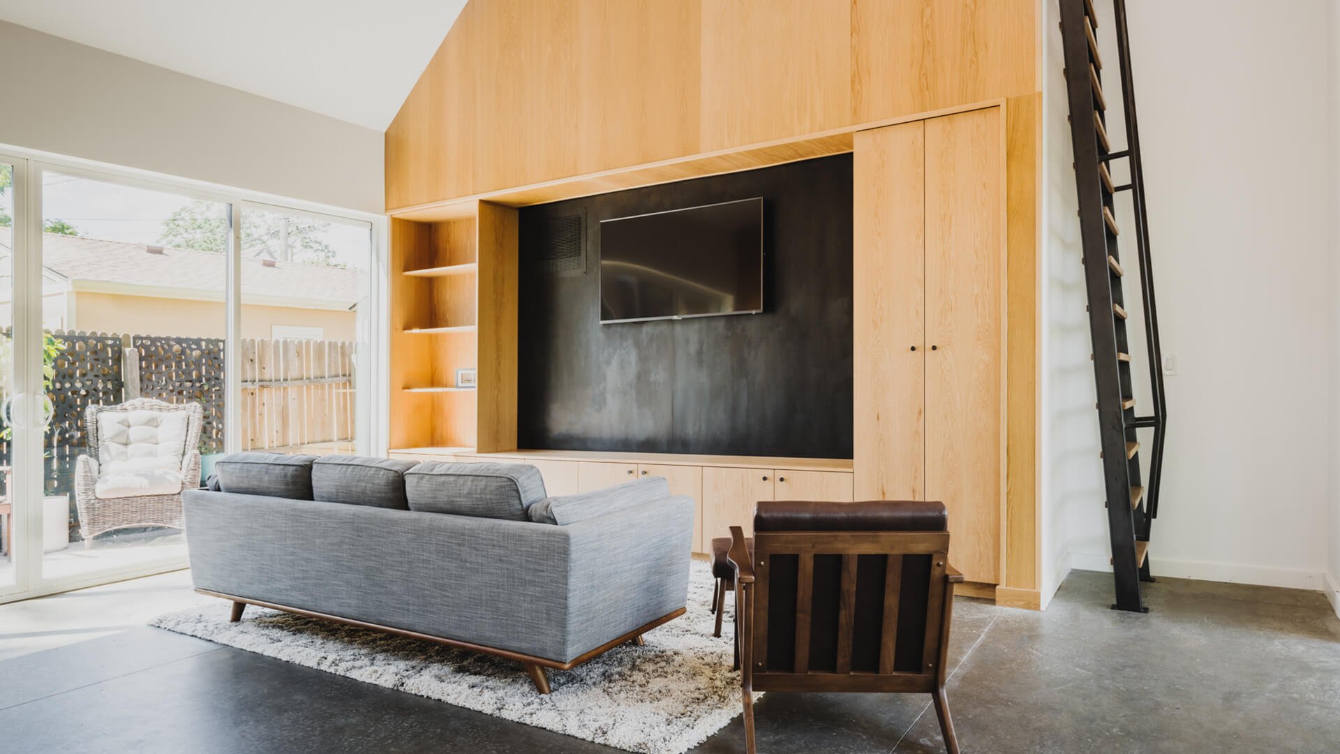 Living area at the Tejon ADU with floor to ceiling built-ins and custom ladder to get to the vaulted space.