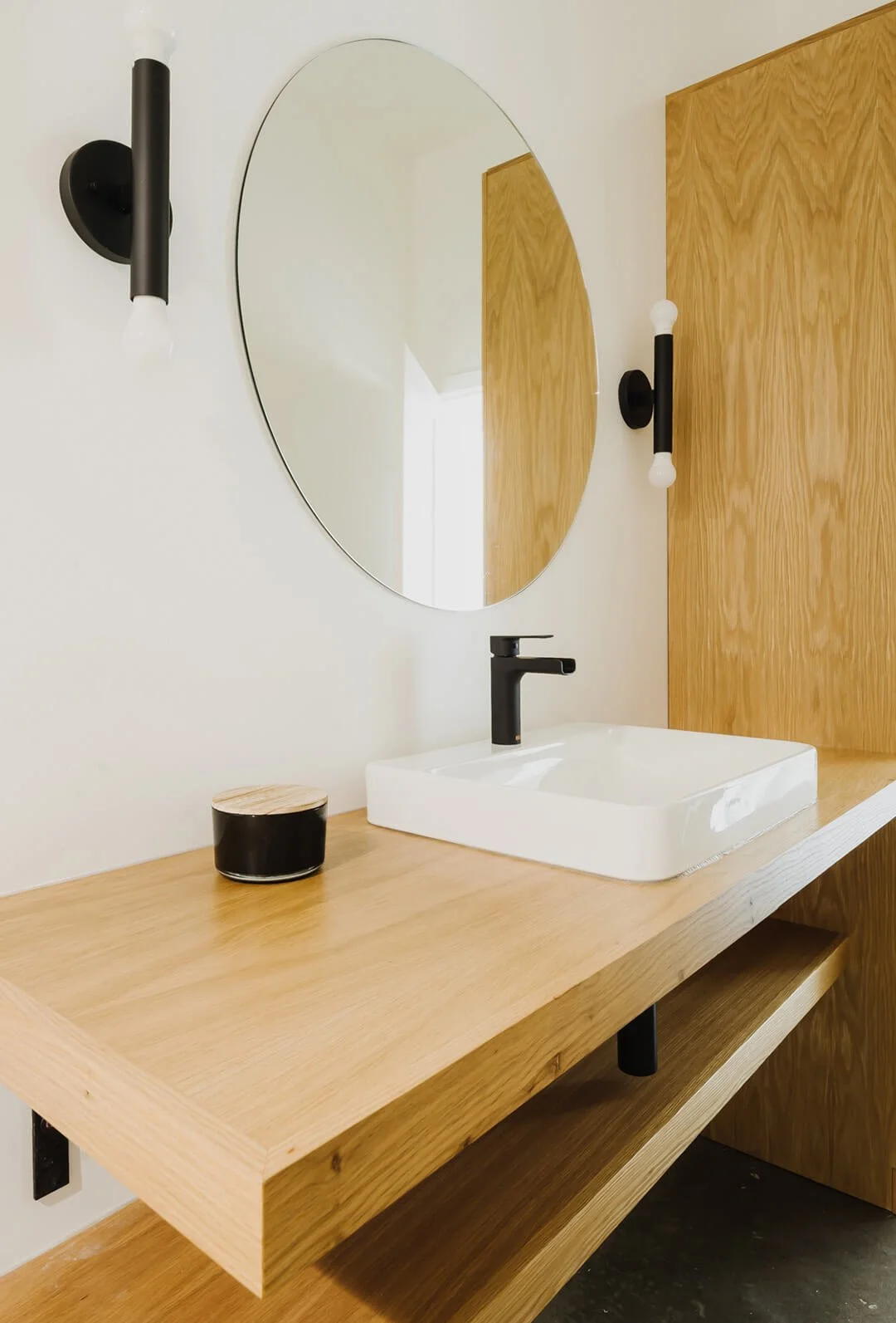 Bathroom with white oak vanity and black details.