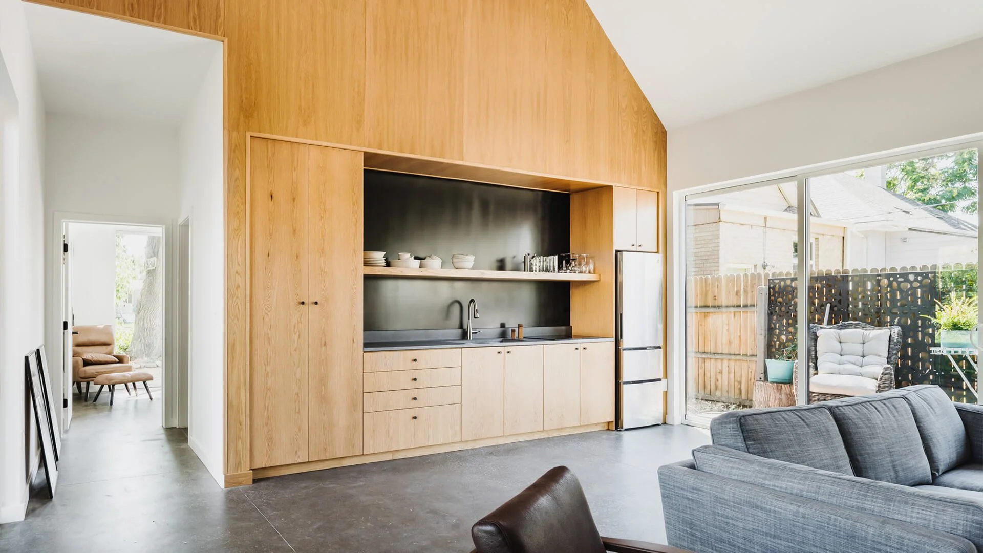 Interior space of an ADU in Denver with white oak cabinetry and an open floor plan with floor to ceiling operable doors.