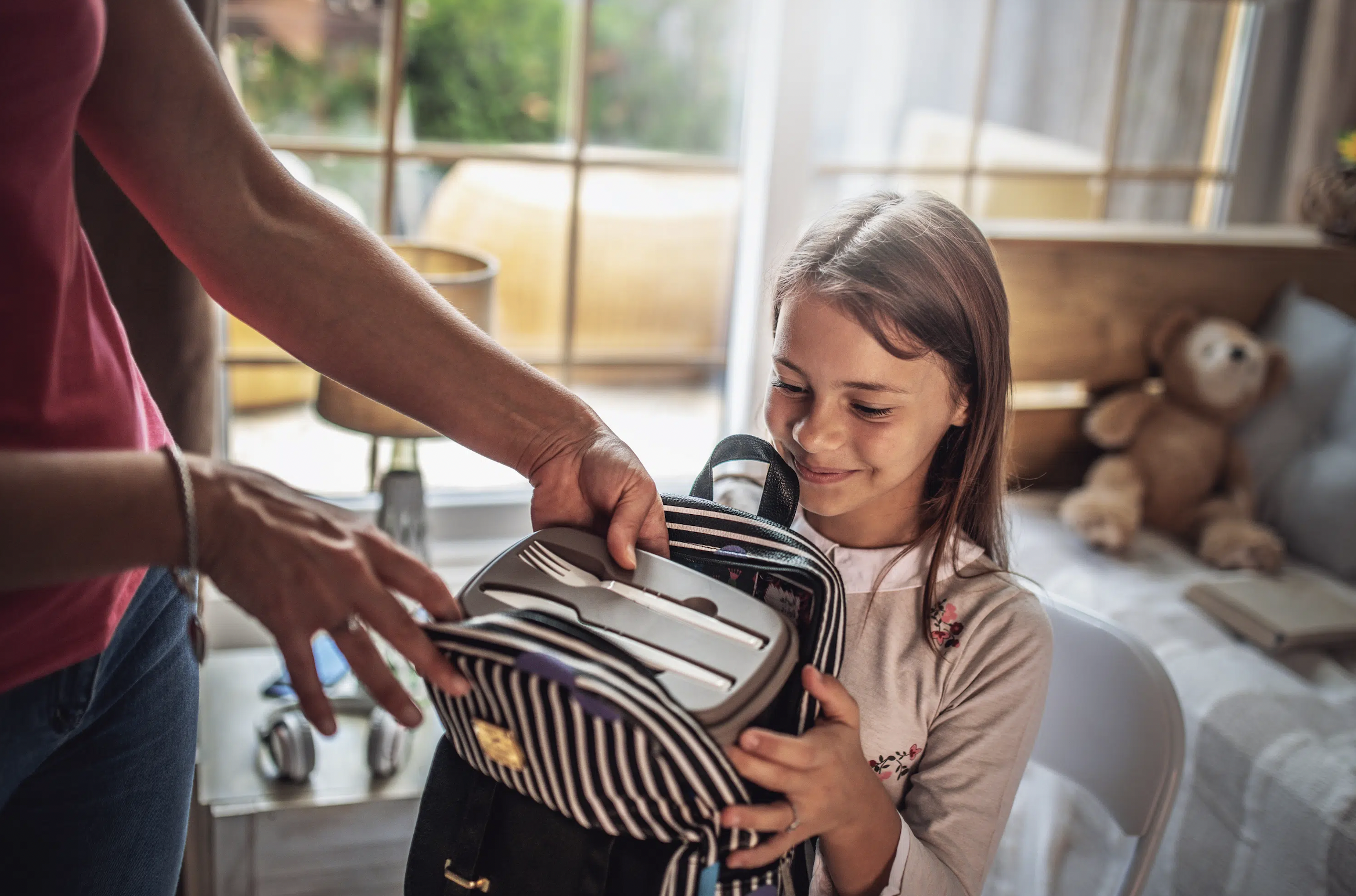 Family assistant helping a child pack a school lunch.