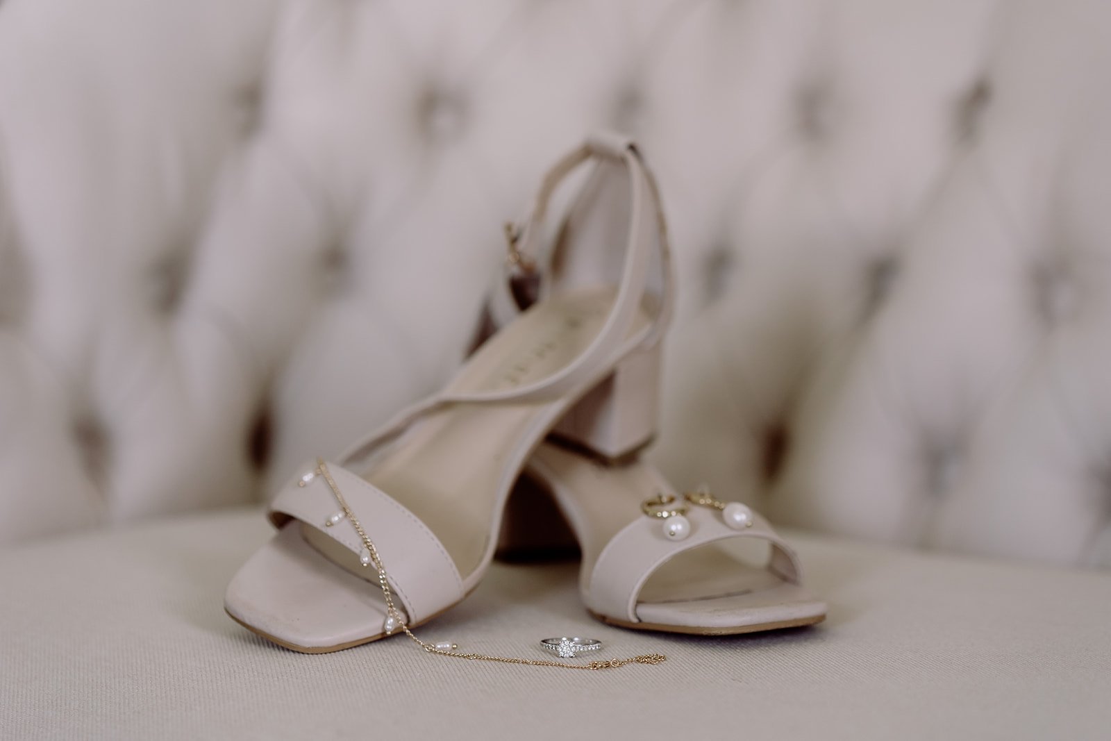 Bride's wedding shoes sitting on cream chaise lounge
