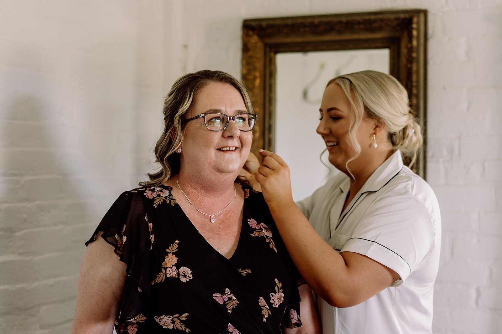 Bride putting her mothers earings on for her wedding day