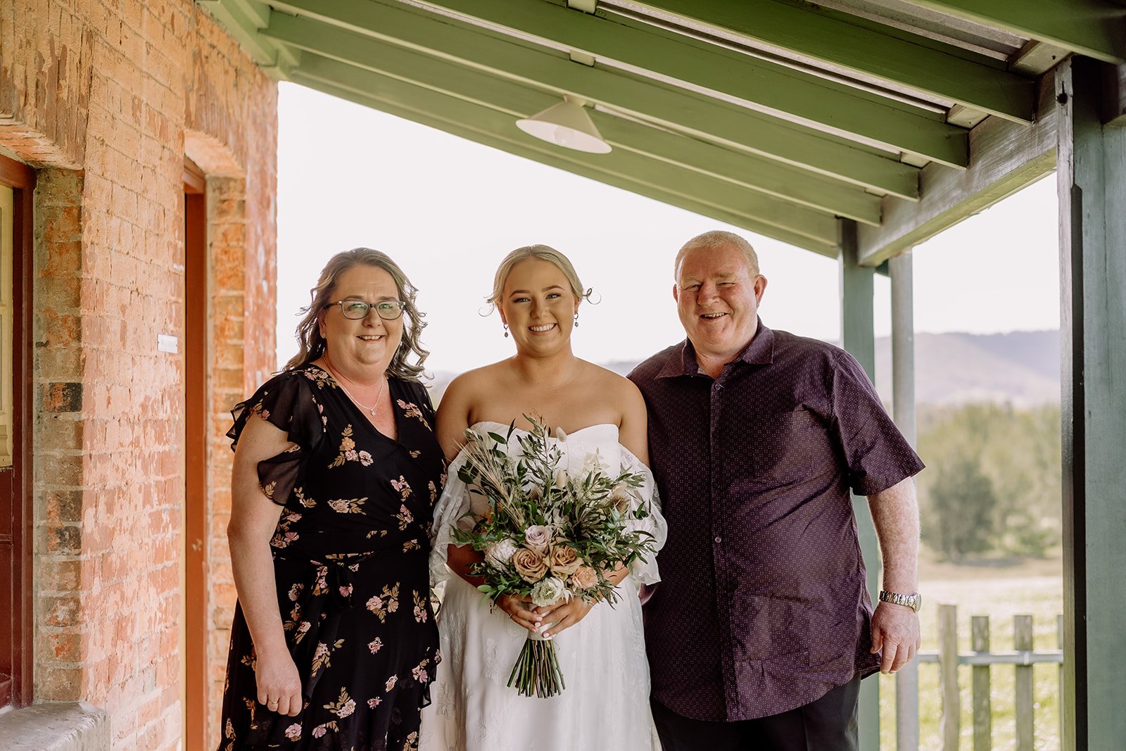 Bride standing with mother and father in her wedding dress at Tocal Homestead