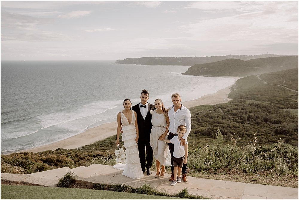 Married couple with family standing at lookout after wedding ceremony in Newcastle