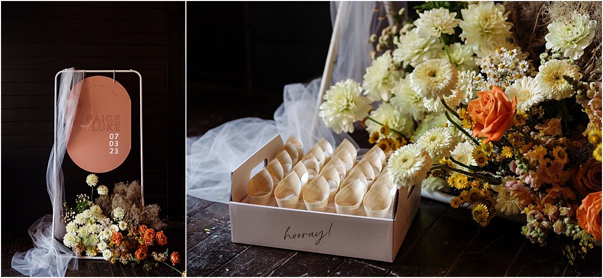 Terracotta wedding sign in pill shape with white tulle draping over, and orange and yellow wedding flowers