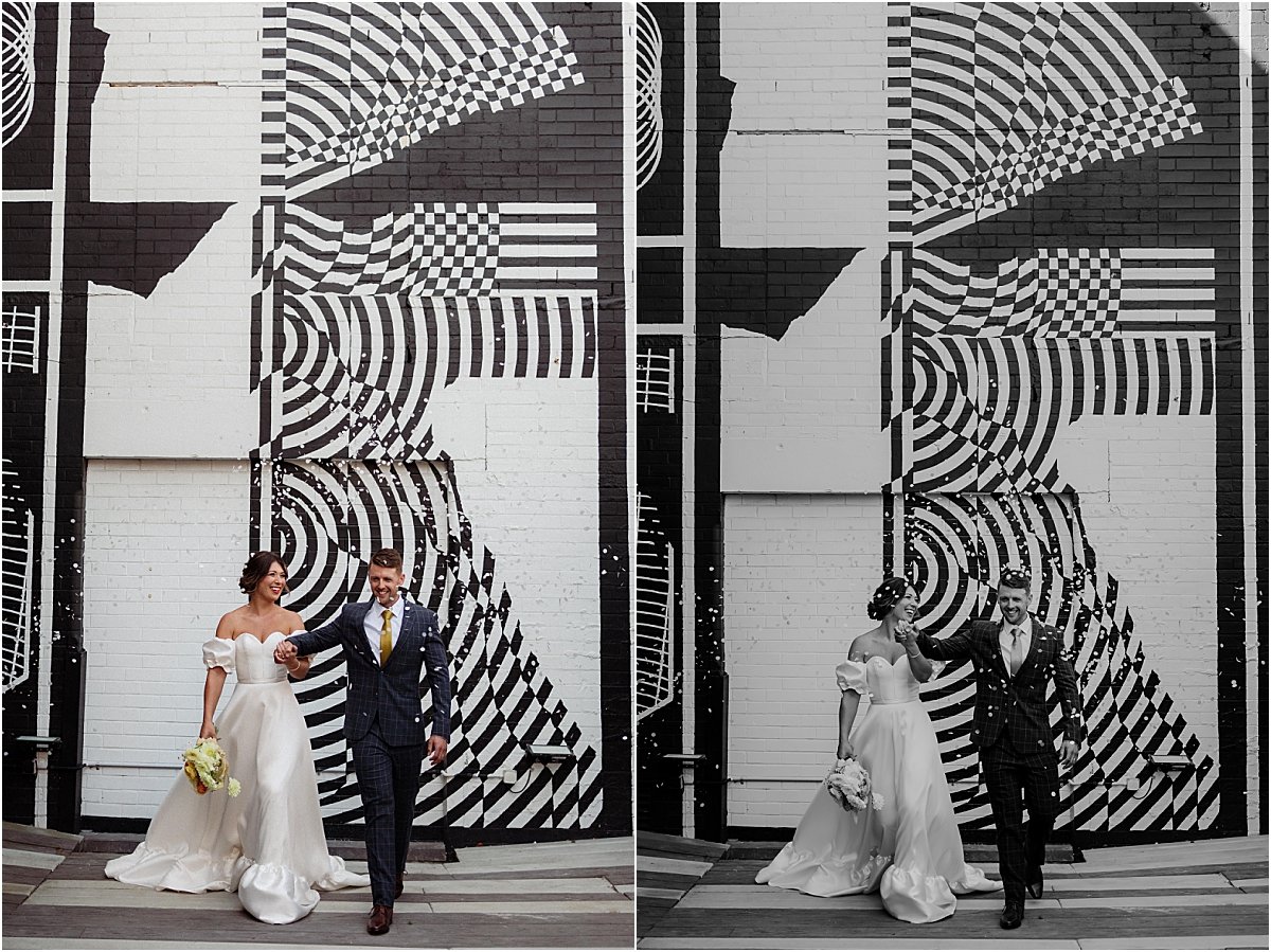 Bride and groom walking  into white bio-degradable confetti in front of black and white mural at the Owens Collective Islington NSW