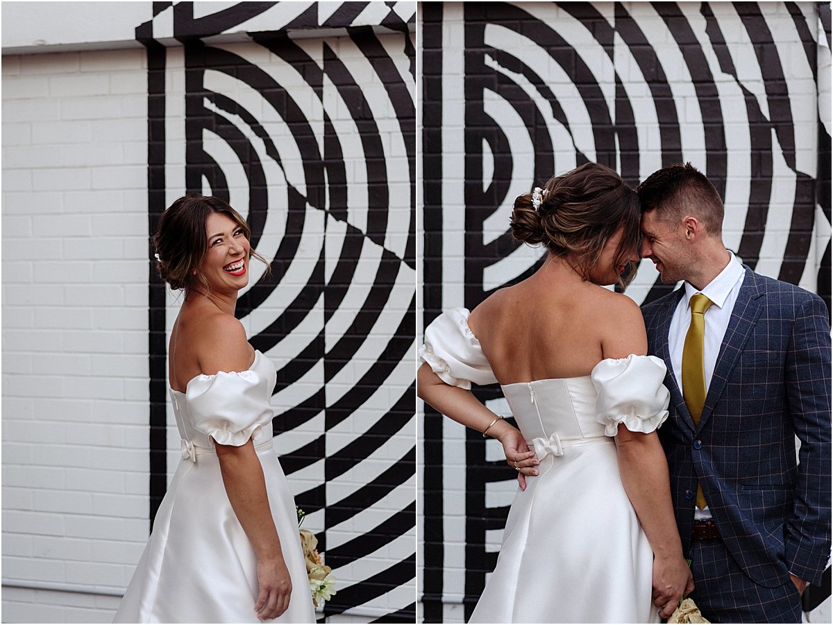 Bride and groom standing in front of black and white mural in Newcastle NSW