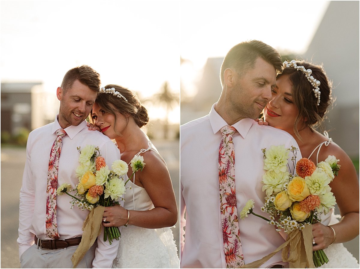 Bride and groom standing with each other at sunset with groom wearing pink floral tie from Rundle Tailoring Newcastle