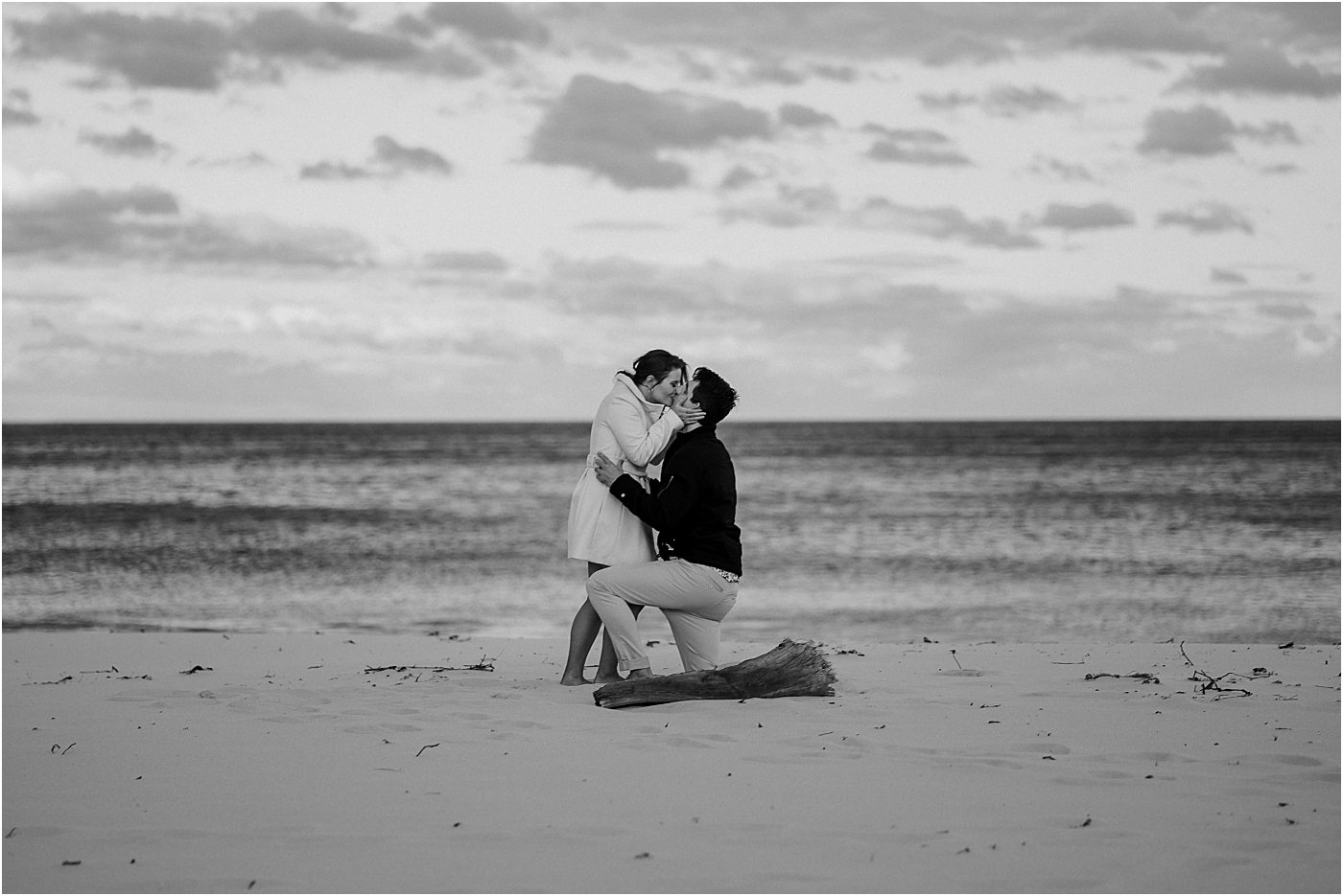 Woman kissing her fiance on the beach at Port Stephens