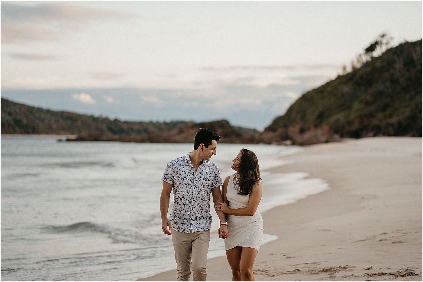 Couple walking along the shoreline of hidden beach Port Stephens NSW