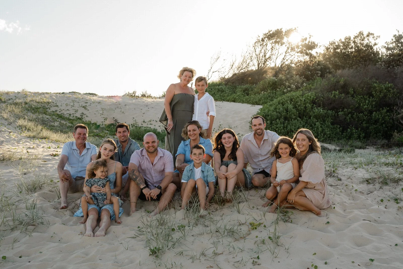 A large family group sitting together at the beach