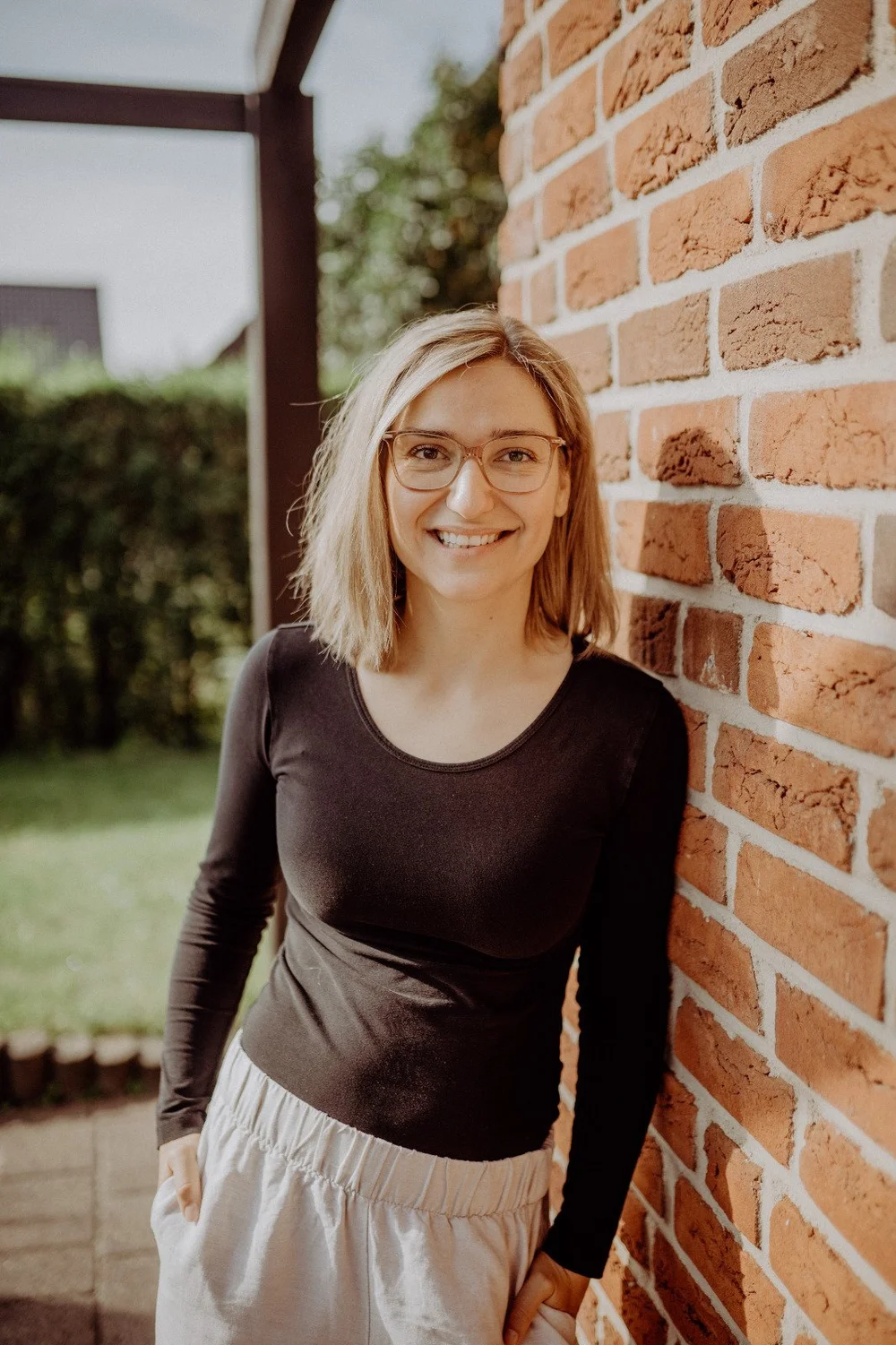 Anka Boshold smiling beside a brick wall
