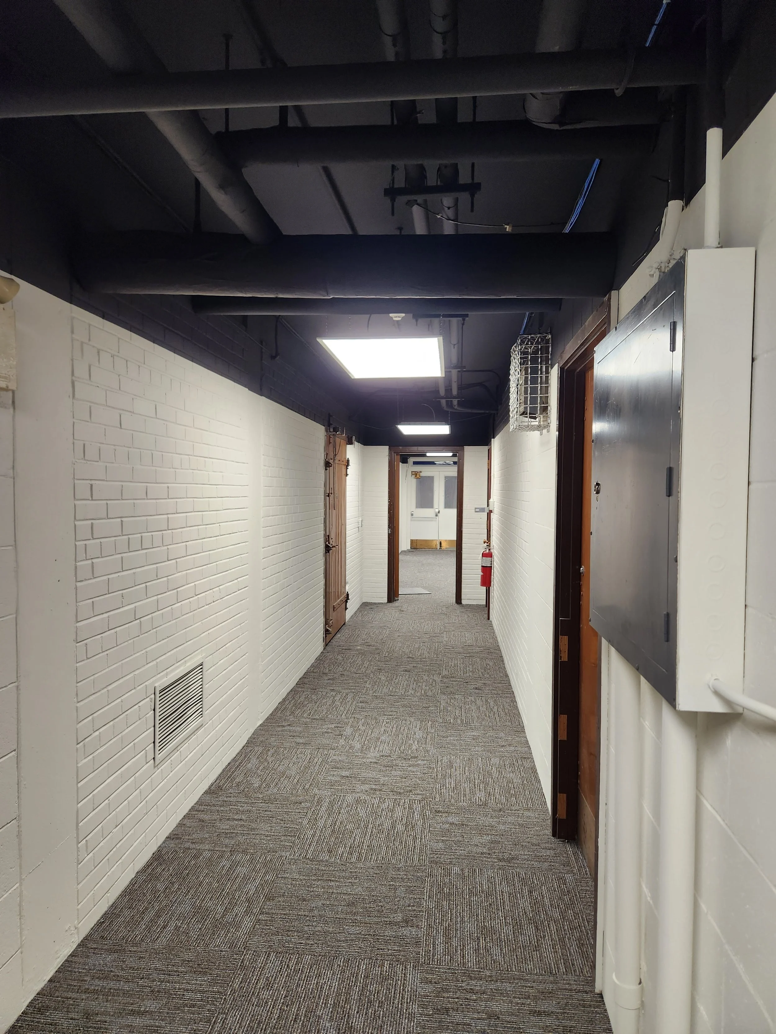 Chilliwack white and black commercial office repaint in a brick hallway with steel doors