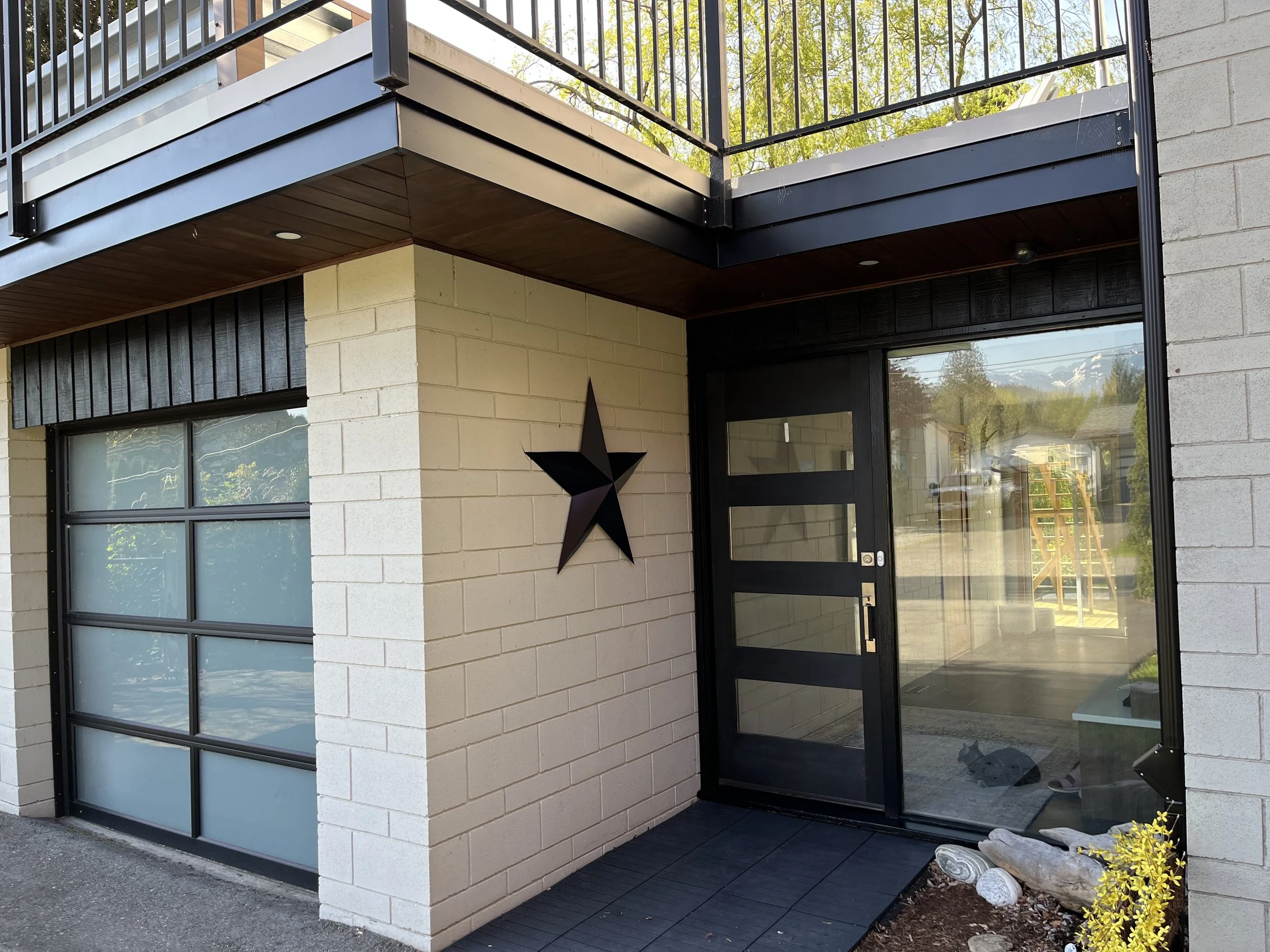 Modern entrance painted in Chilliwack with glass door and star decoration on wall