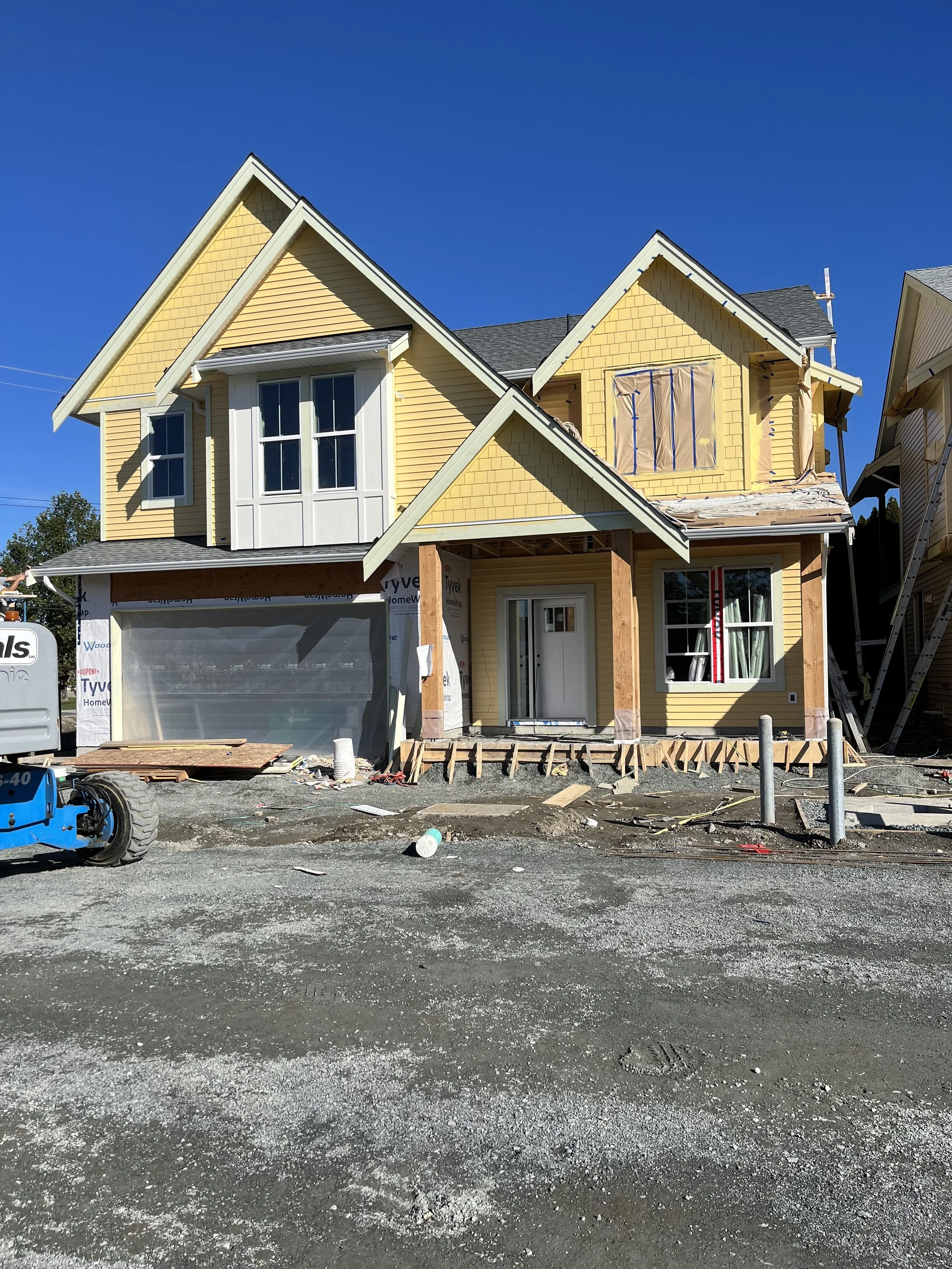 Exterior new construction house in Chilliwack with yellow and white siding
