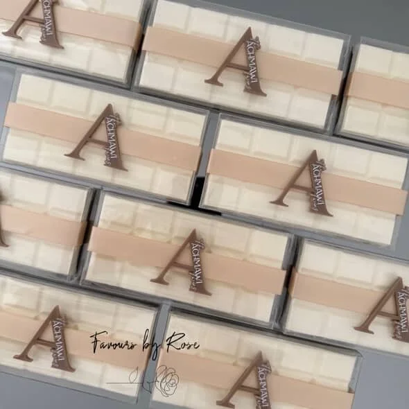 Several boxes of chocolates with a little chocolate letter and a ribbon that says "Fitzwilliam" on a light-colored surface.