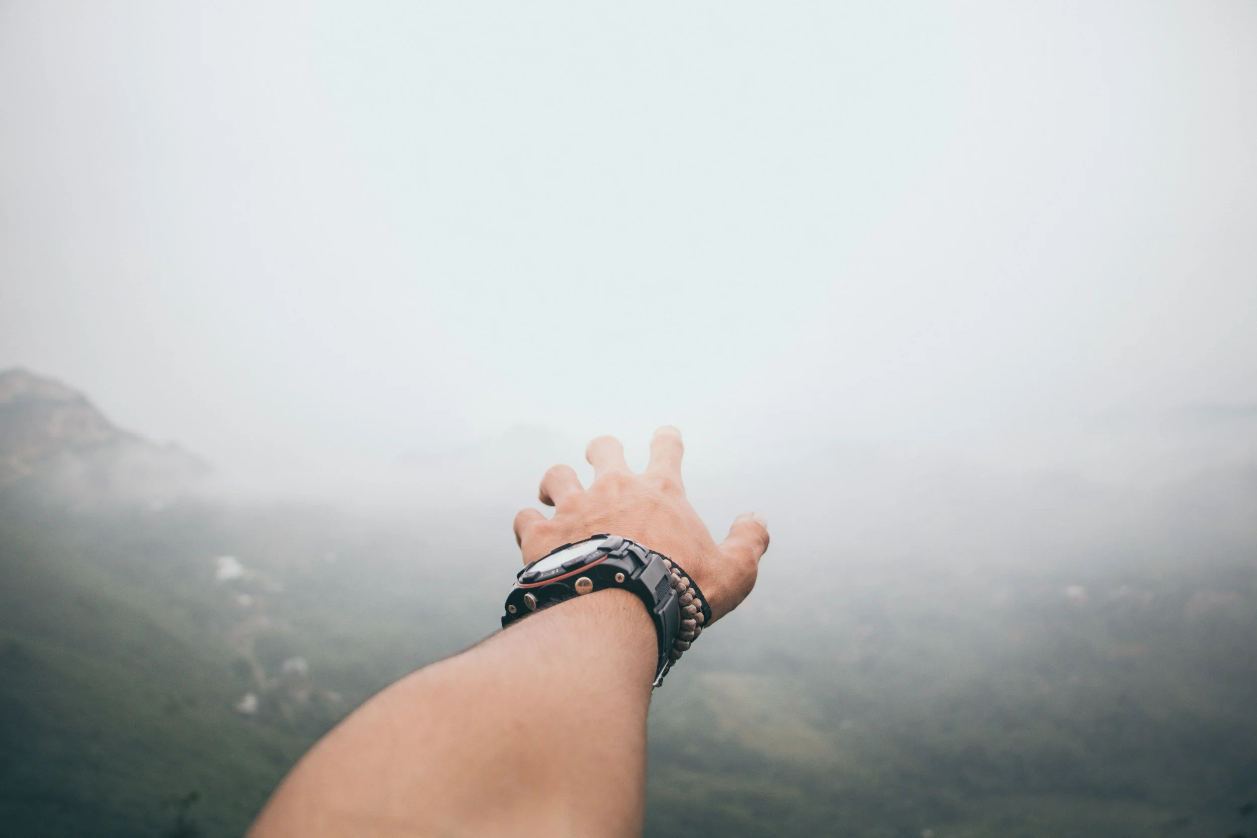 image of hand with watch and bracelets reaching out to the sky symbolizing looking for connection in their relationships
