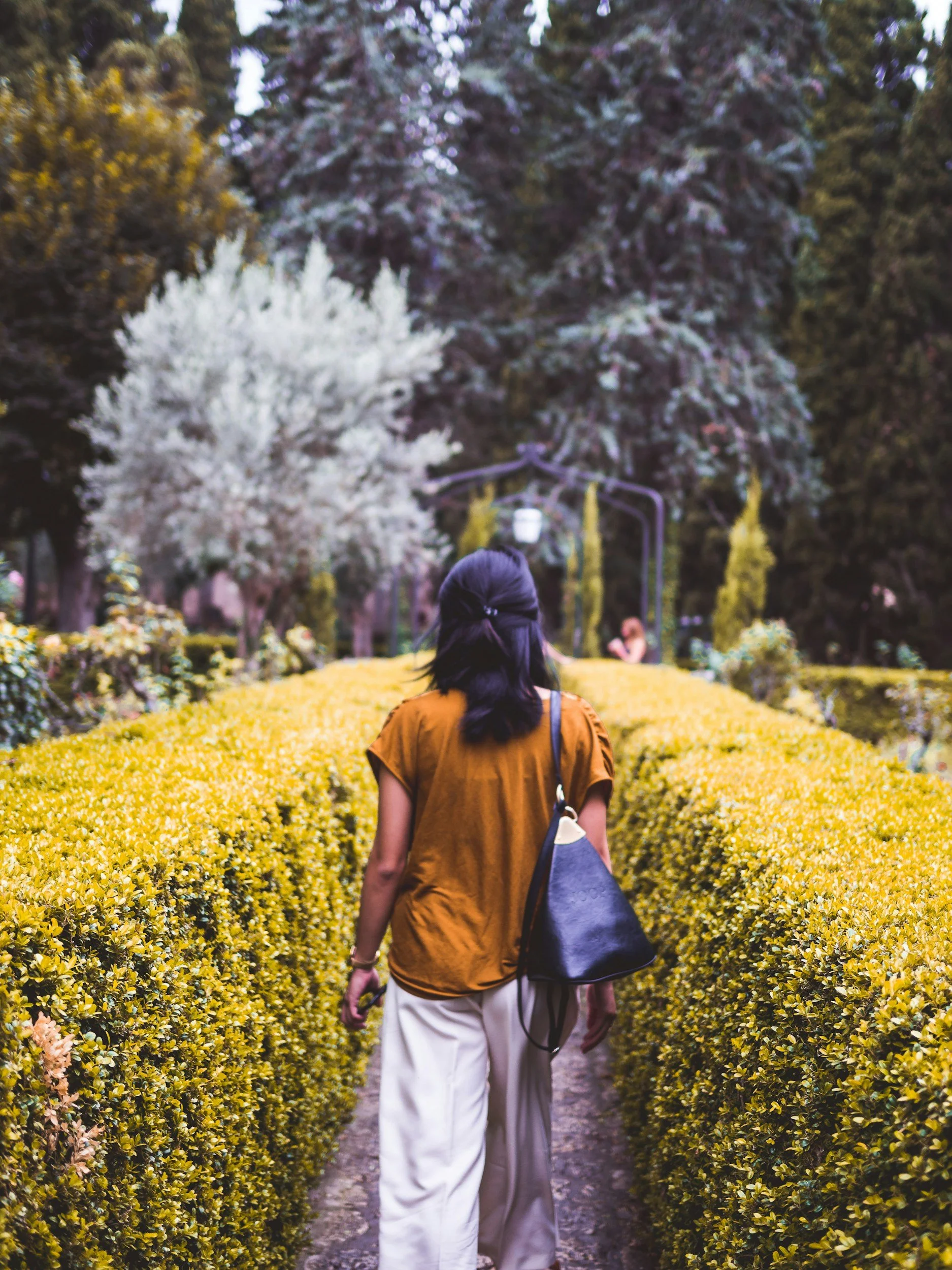 woman walking in a botanical garden representing the importance of everyday practices that mold people
