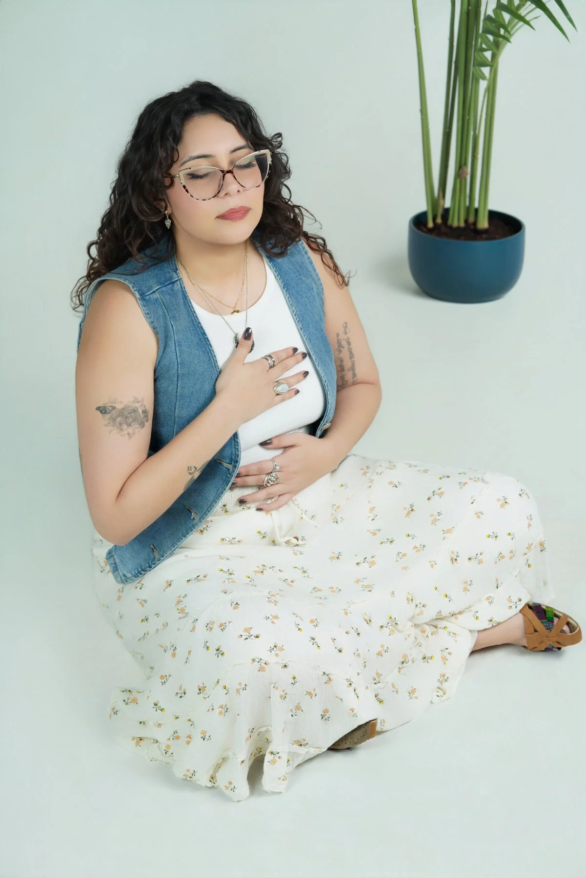 therapist on floor practicing tools to help self-soothe anxiety for therapy in los angeles wearing tattoos and denim vest and crystals