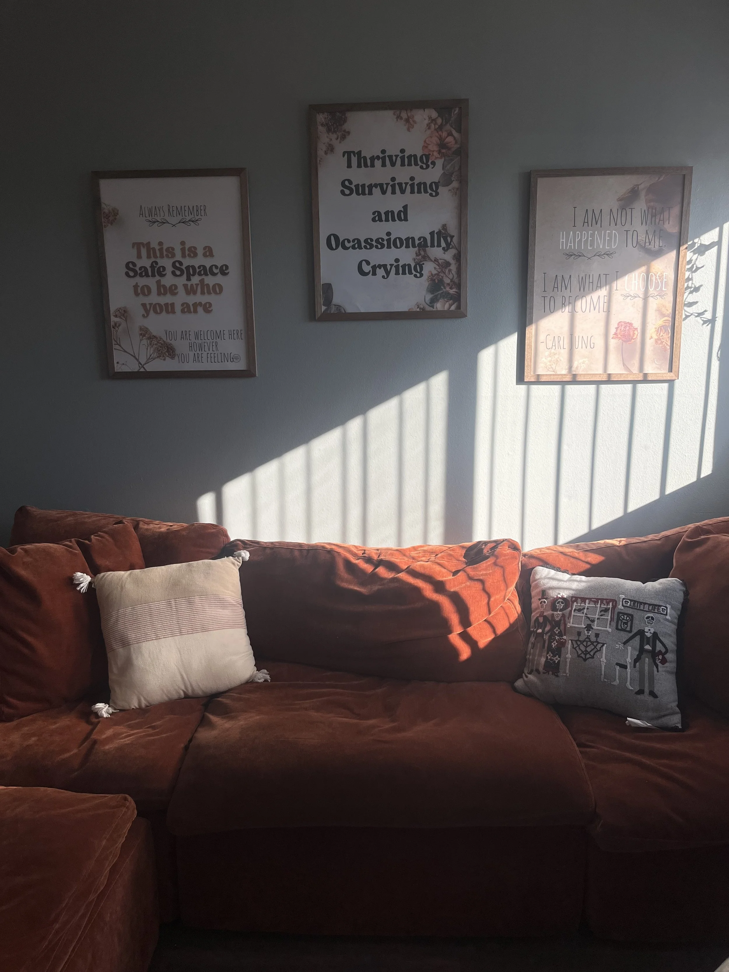 image of burgundy couch and safe space frames setting the background for home office for online therapy in california