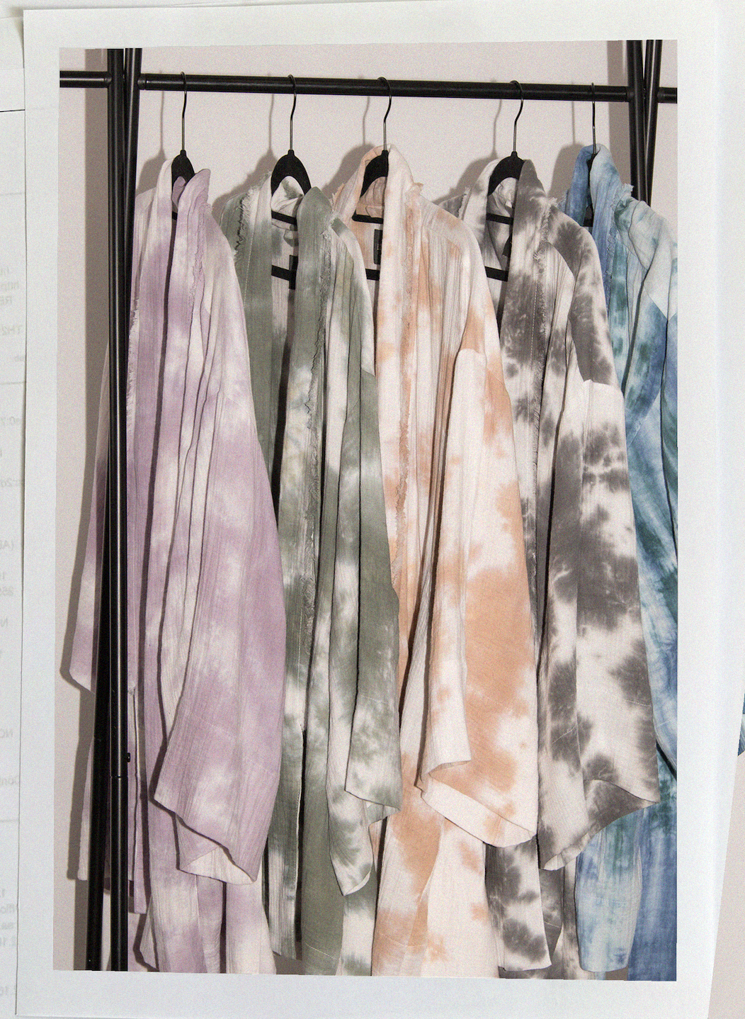 Vêtements en tissu tie-dye suspendus sur une tringle de vêtement.