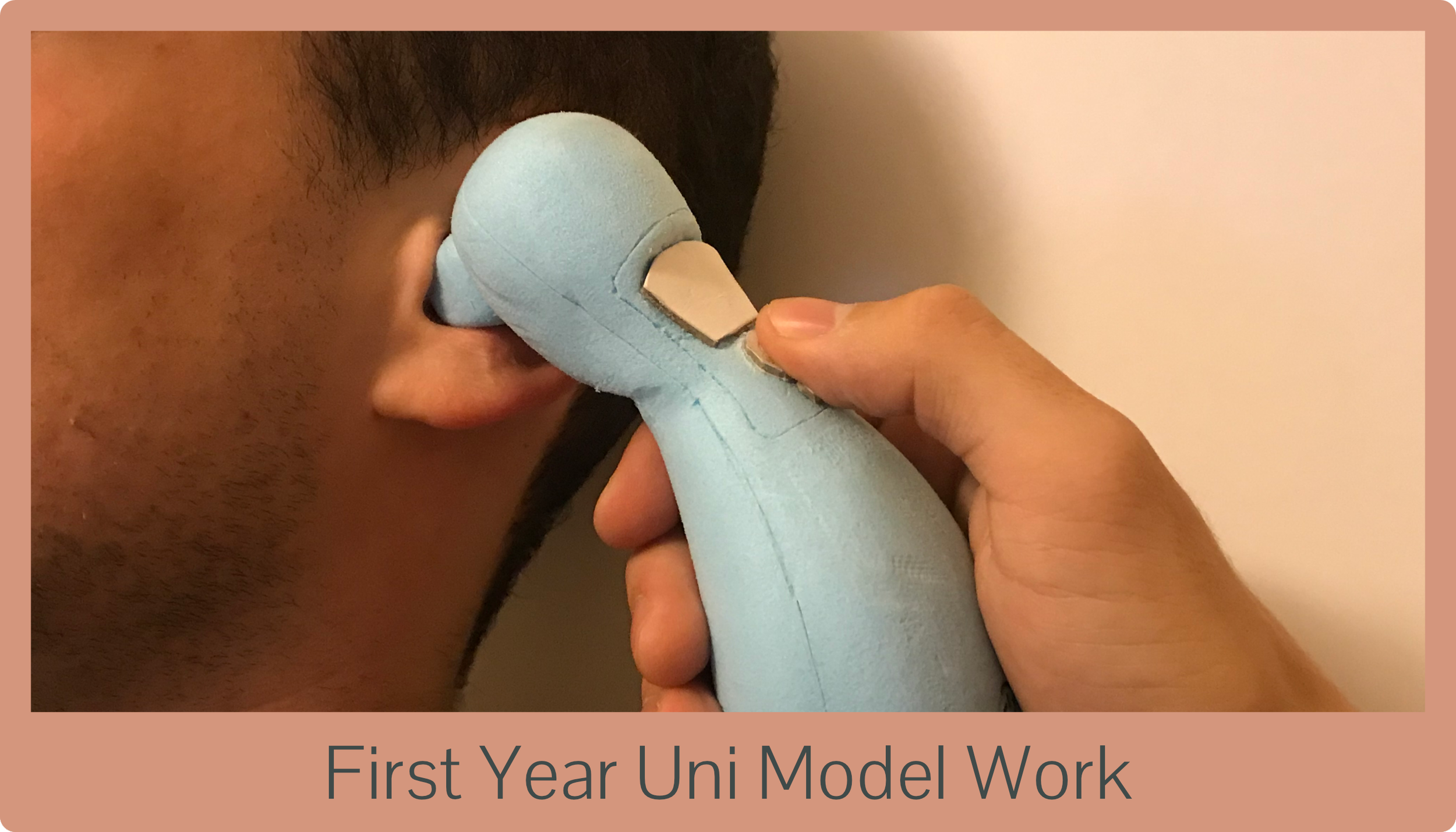 A person applying a prosthetic ear model to their head during first year university model work.