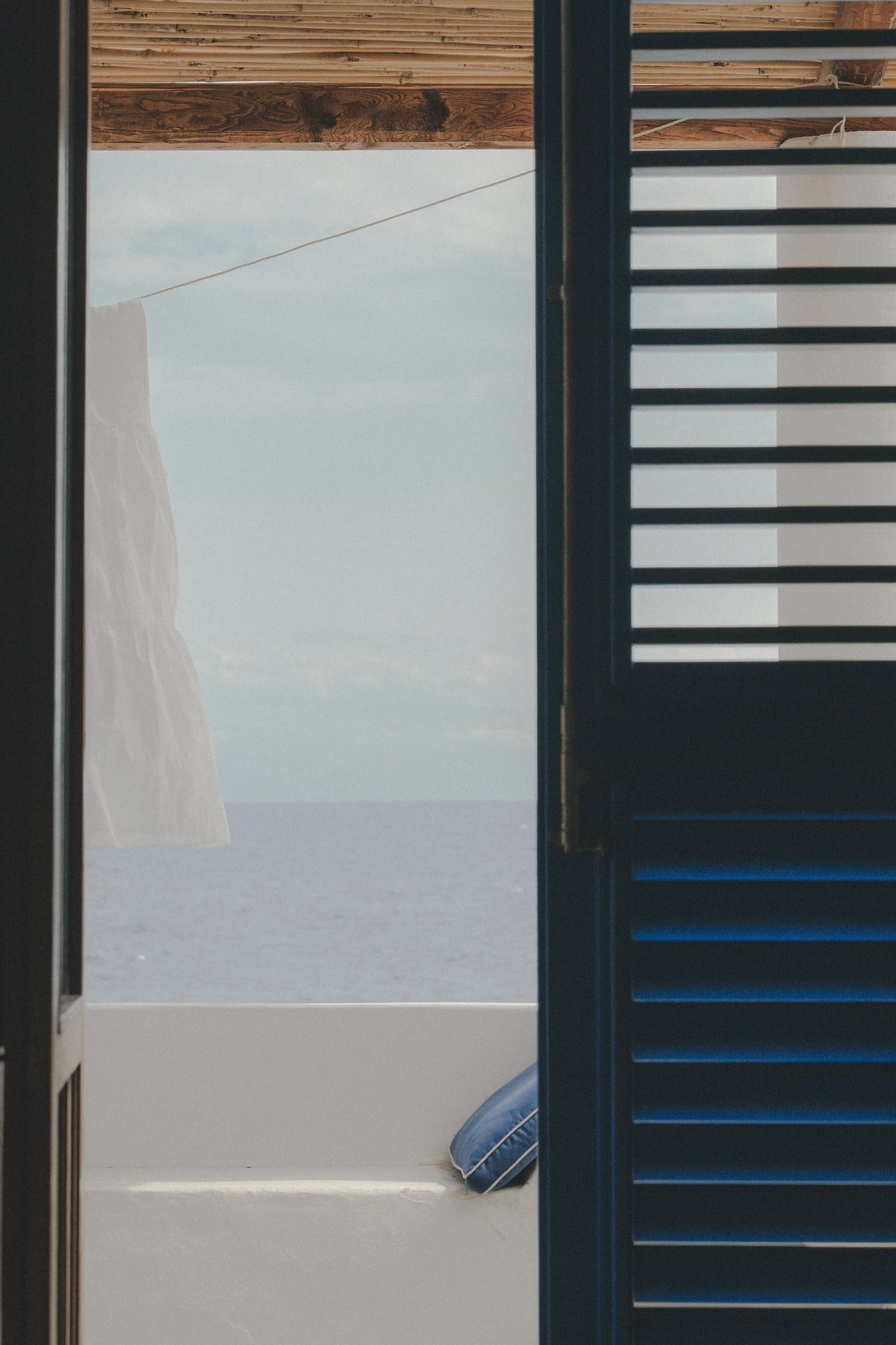 hospitality : vue mer depuis une maison éolienne à Alicudi, porte bleue ouverte