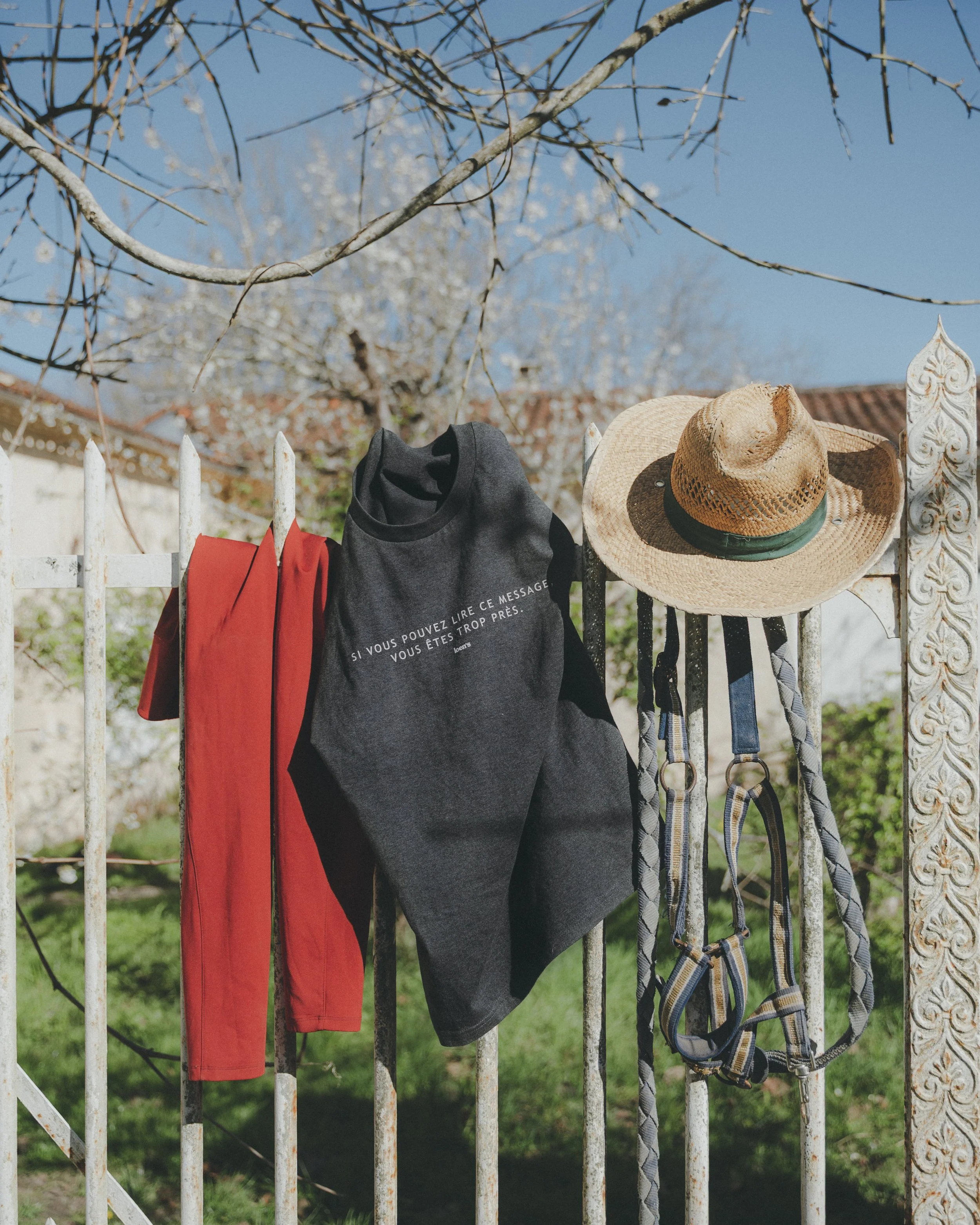 Vêtements Loen’s Equestrian accrochés à une barrière en décor équestre