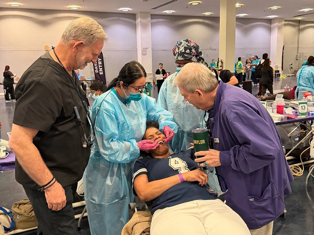 Dr Larry Herwig and Dr Jon Williamson overseeing a TAMU College of Dentistry student providing care to a patient.jpg