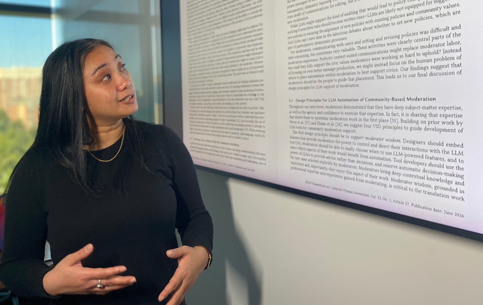 Lovely-Frances Domingo explains her study, which is projected on a screen behind her, on using AI for content moderation on Reddit.