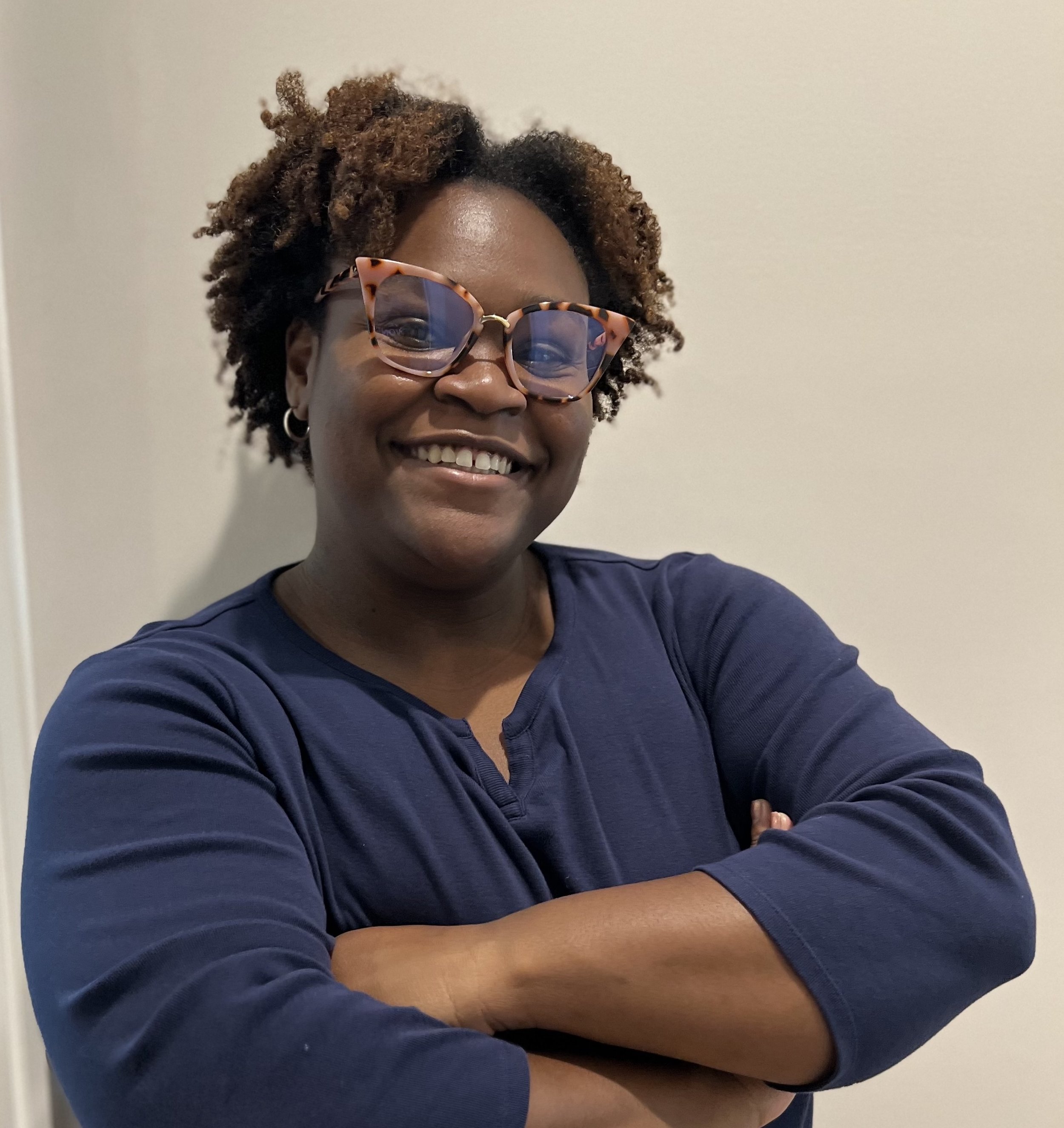 Keshiyena Pieters smiling with arms crossed